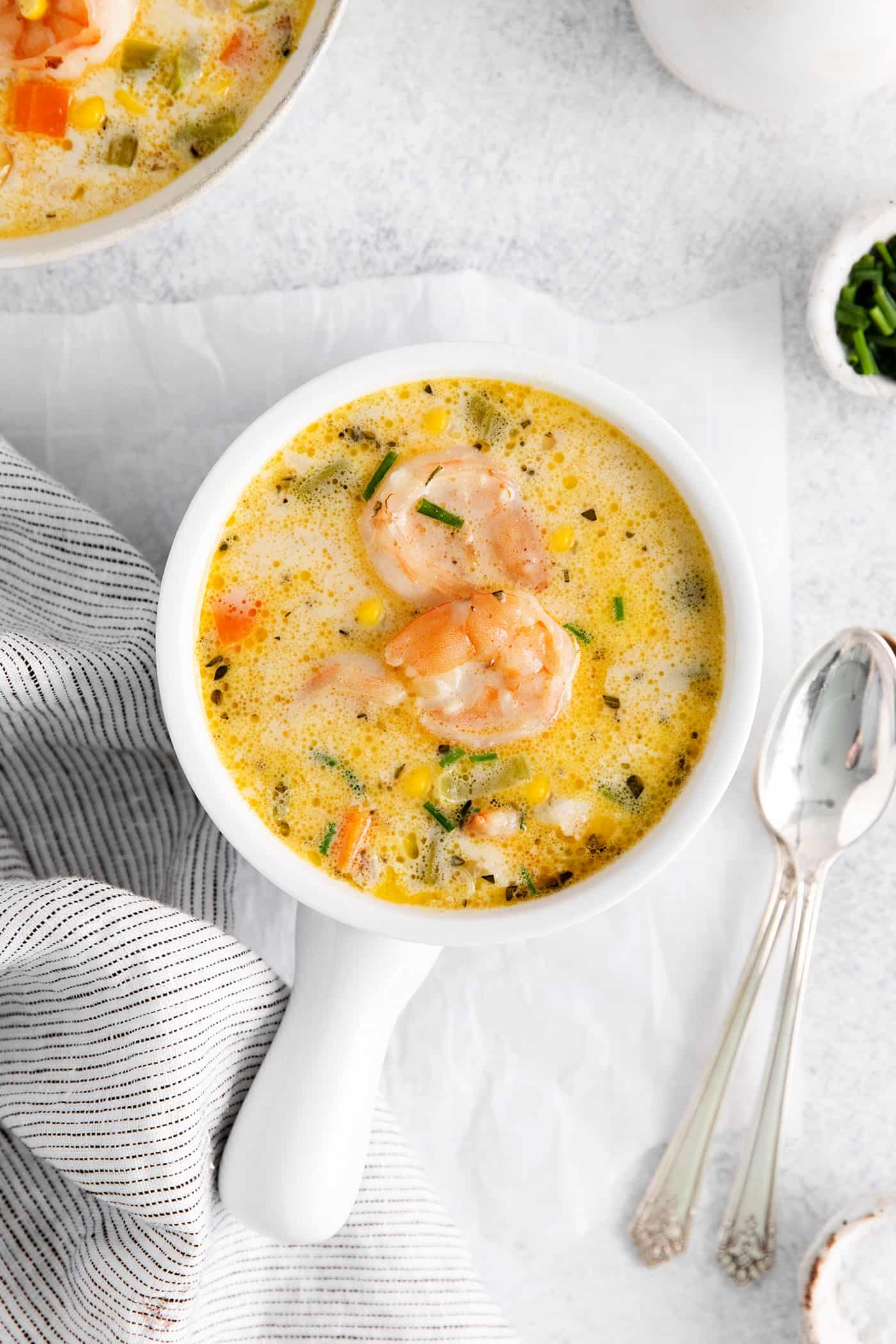 This shrimp and corn chowder has a light, creamy broth and is filled with sautéed vegetables, tender shrimp, and fresh sweet corn. Overhead view of a bowl of shrimp and corn chowder