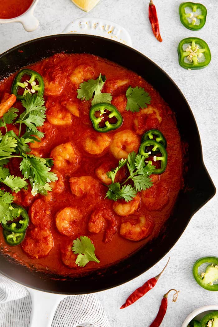 Camarones a la Diabla is a classic Mexican seafood dish that features fresh shrimp, dried chiles, and ripe tomatoes. Ready in 30 minutes! Overhead view of camarones a la diabla in a cast iron skillet