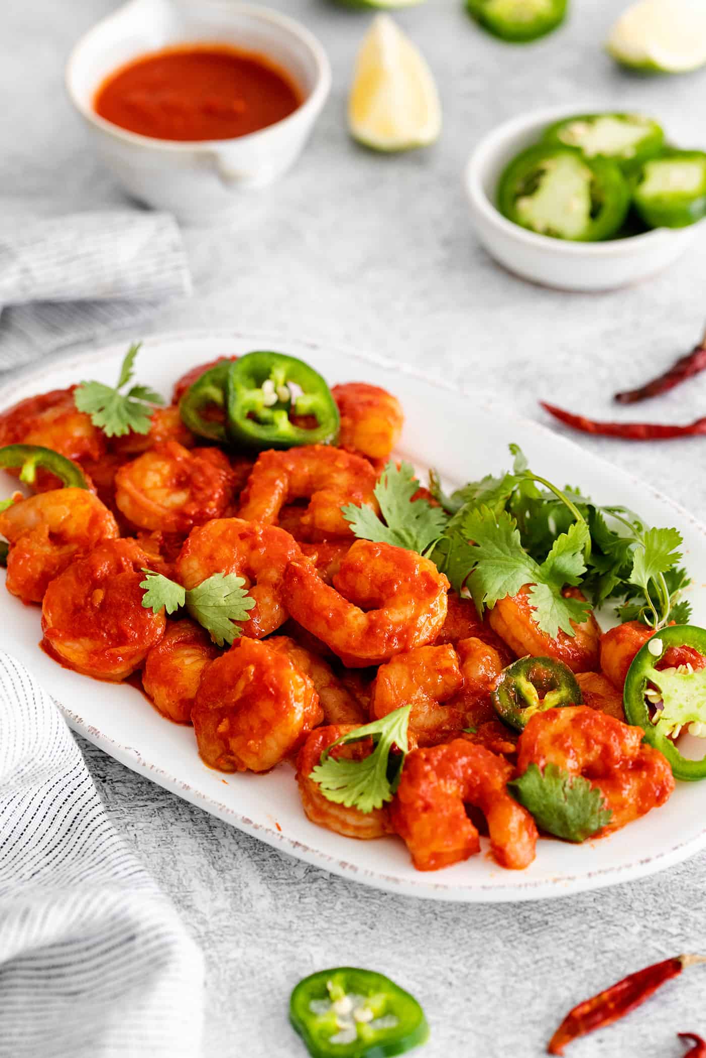 Camarones a la Diabla is a classic Mexican seafood dish that features fresh shrimp, dried chiles, and ripe tomatoes. Ready in 30 minutes! Diablo shrimp on a white serving platter
