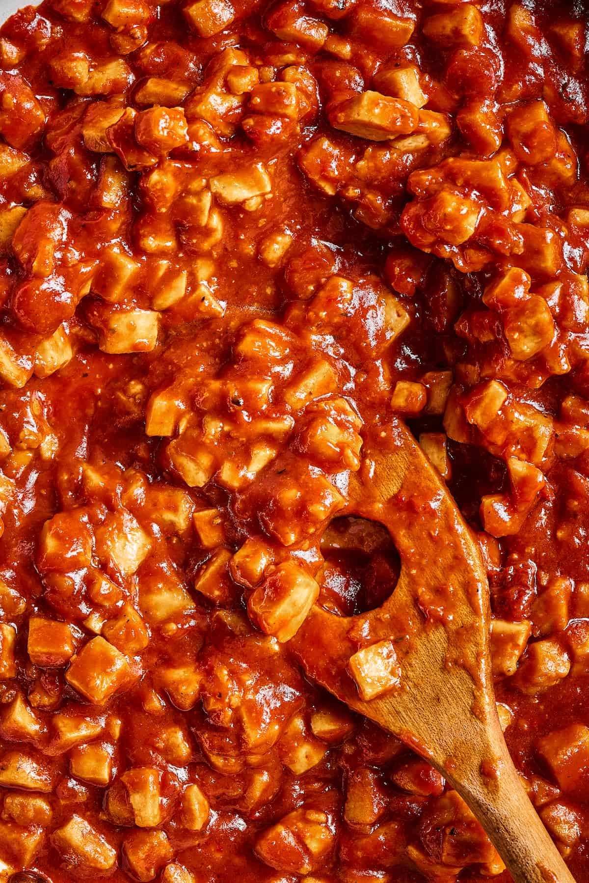 Close-up of a wooden spoon stirring vegan sofritas