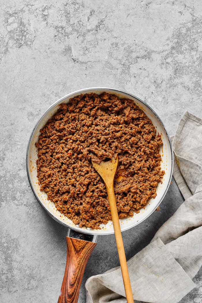 Made with taco meat, refried beans, and enchilada sauce layers with tortillas and cheese, Mexican Pizza is easy & tasty. Taco meat in a pan