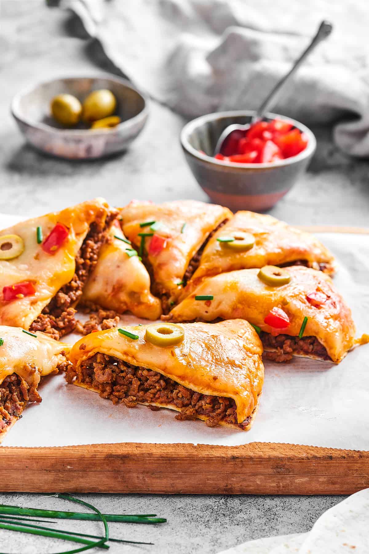 Made with taco meat, refried beans, and enchilada sauce layers with tortillas and cheese, Mexican Pizza is easy & tasty. Mexican pizza cut into slices
