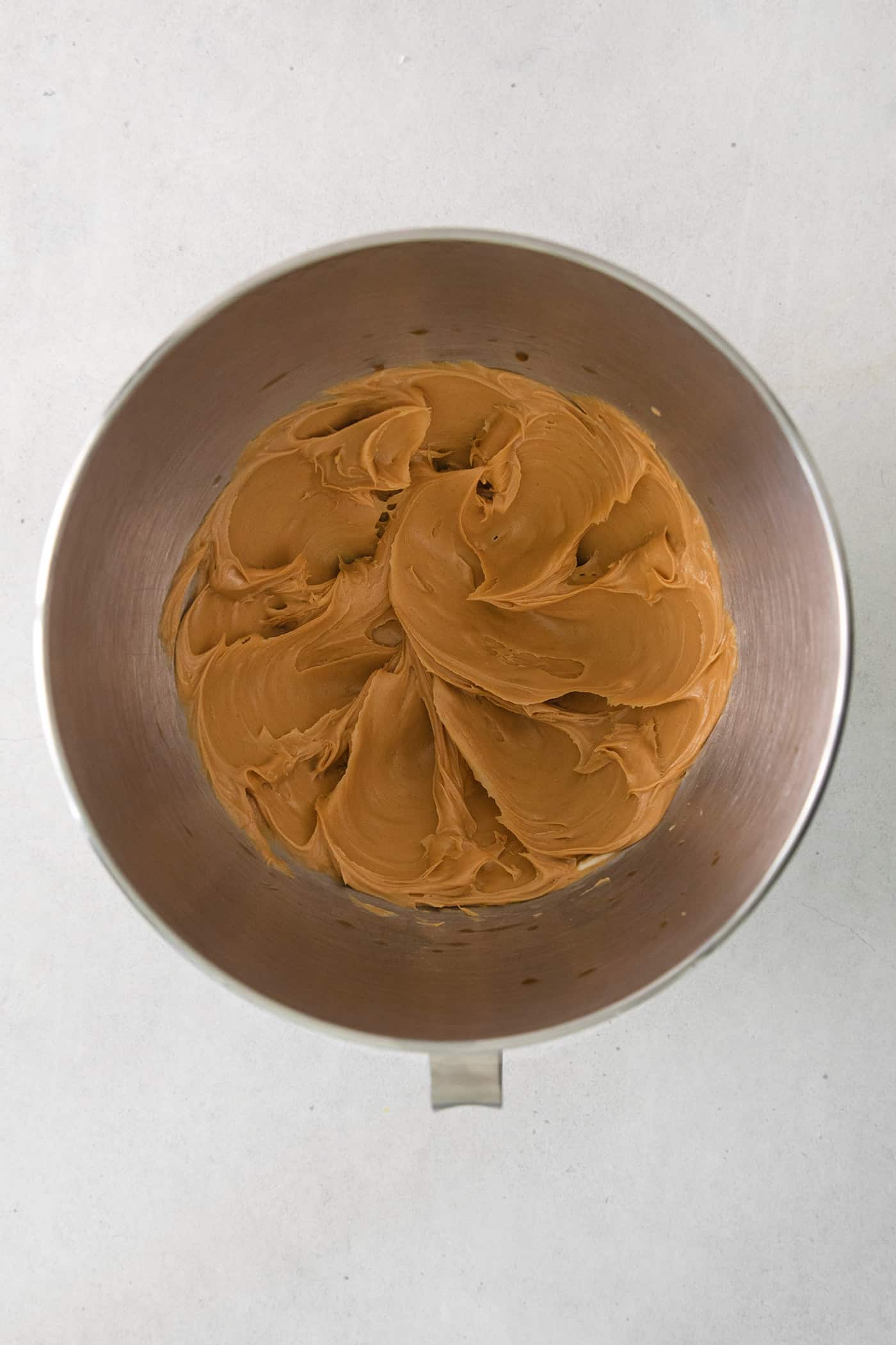 These Homemade Buckeyes feature creamy peanut butter balls dipped in rich, smooth semi-sweet chocolate. Just 7 ingredients! Creamed peanut butter and butter in a mixing bowl
