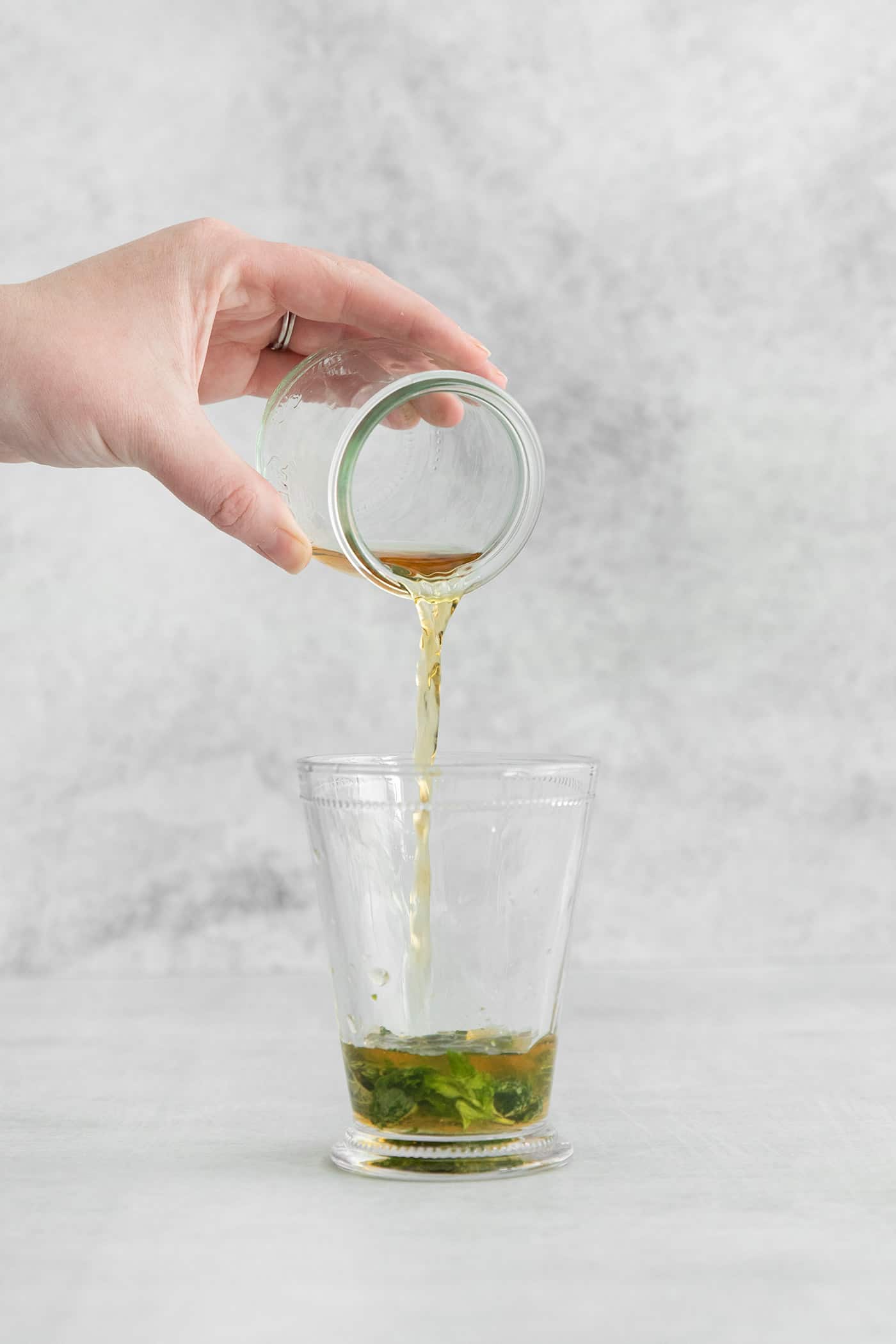 This classic Mint Julep is bright and refreshing, with fresh mint flavor and a hint of smoky bourbon. All you'll need is 3 ingredients! Bourbon being poured into a glass over muddled mint