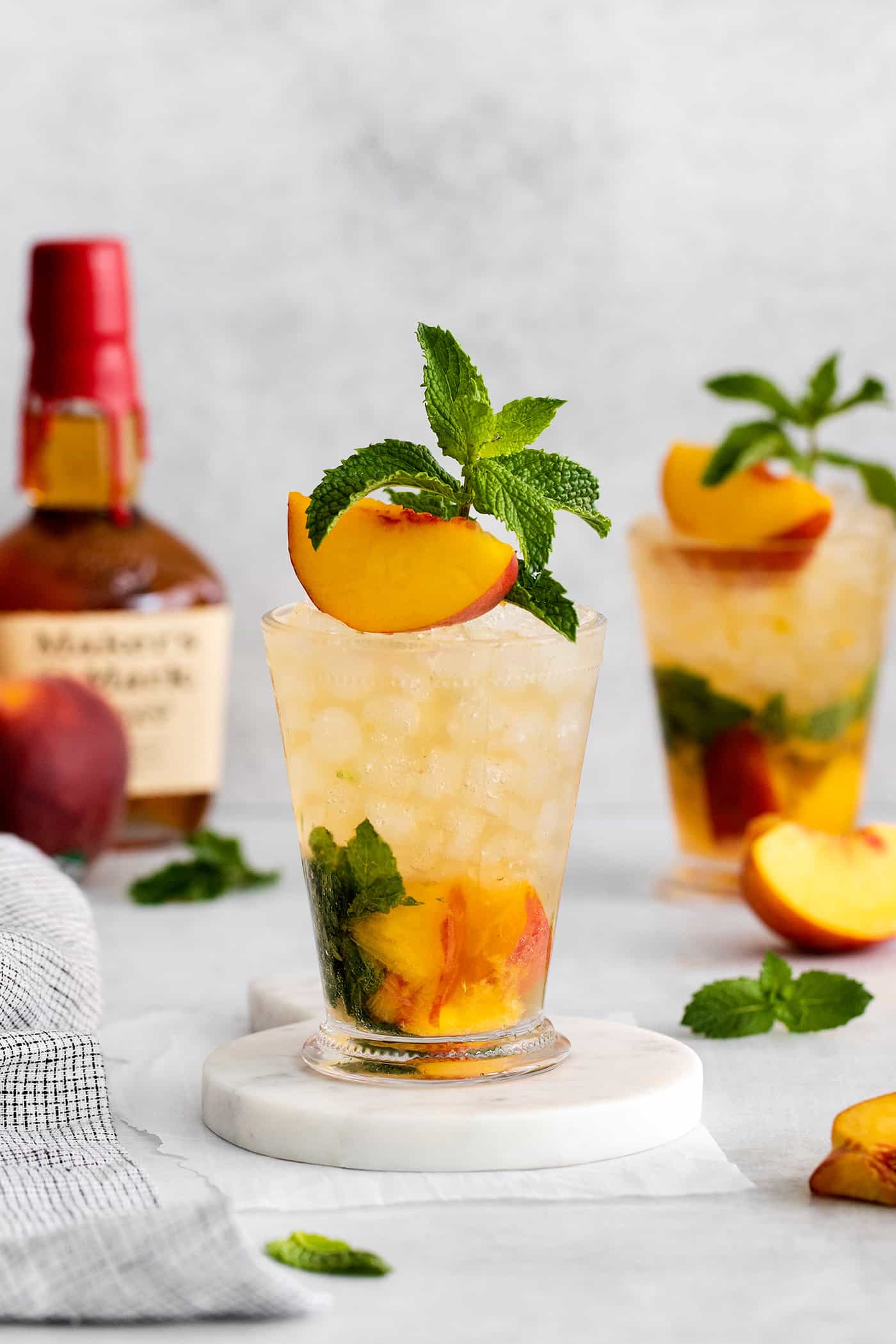 This Peach Mint Julep is bright, fresh, and fruity, with a hint of spice from fresh ginger. The perfect summer cocktail! Two peach mint julep cocktails
