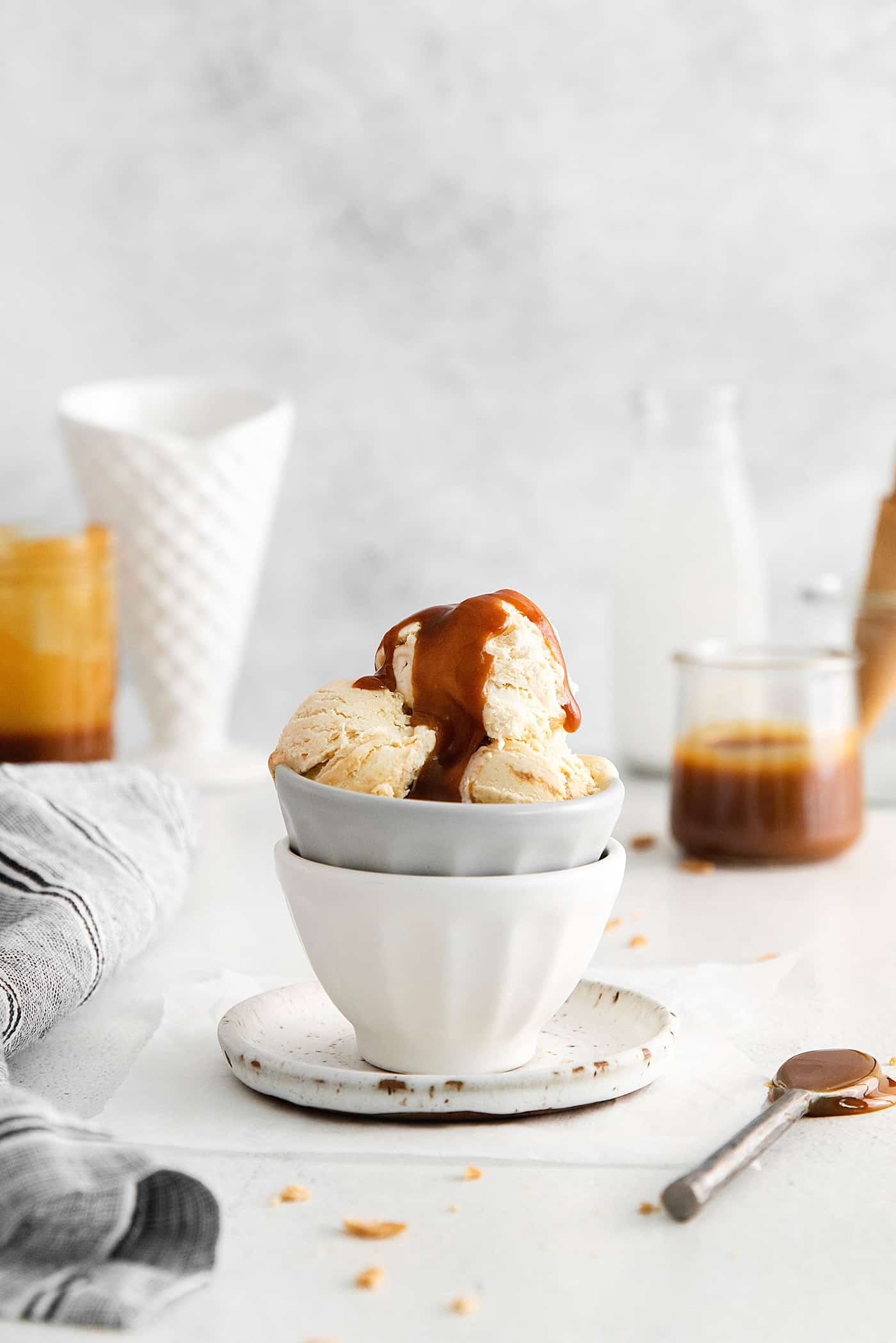 This Salted Caramel Ice Cream features a sweet and creamy ice cream base with homemade caramel sauce swirled throughout. A bowl of ice cream topped with caramel sauce