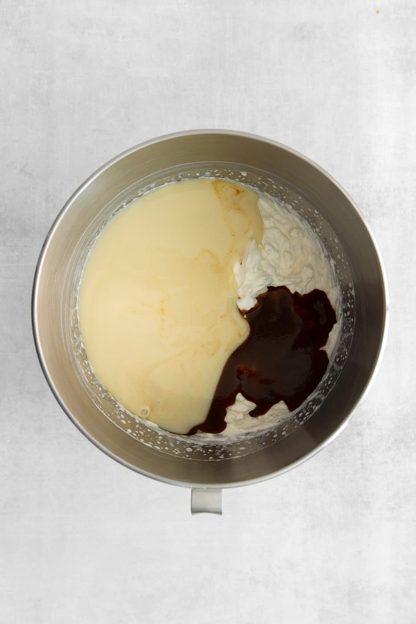 This Salted Caramel Ice Cream features a sweet and creamy ice cream base with homemade caramel sauce swirled throughout. Homemade ice cream ingredients in a mixing bowl
