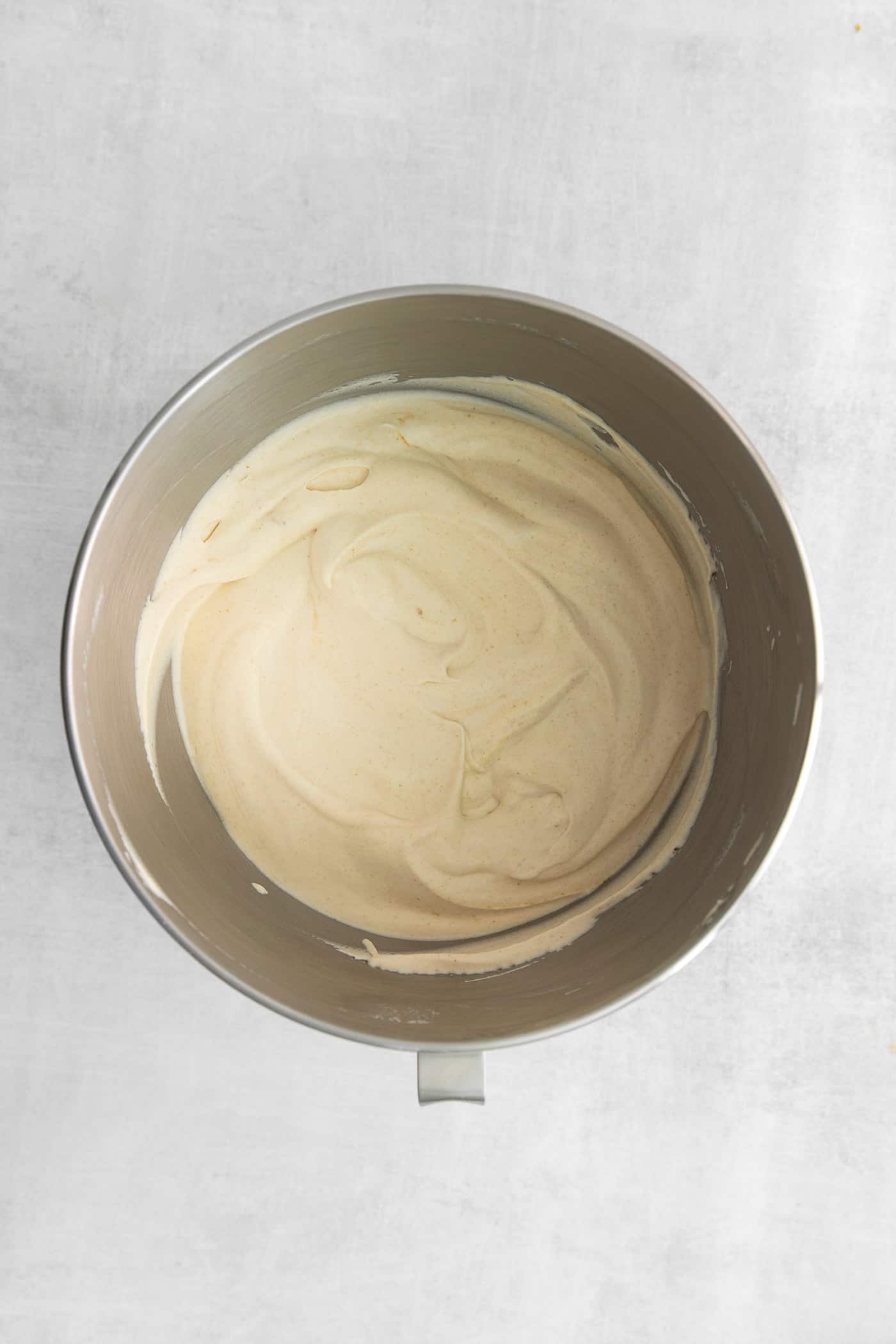 This Salted Caramel Ice Cream features a sweet and creamy ice cream base with homemade caramel sauce swirled throughout. Homemade ice cream in a mixing bowl