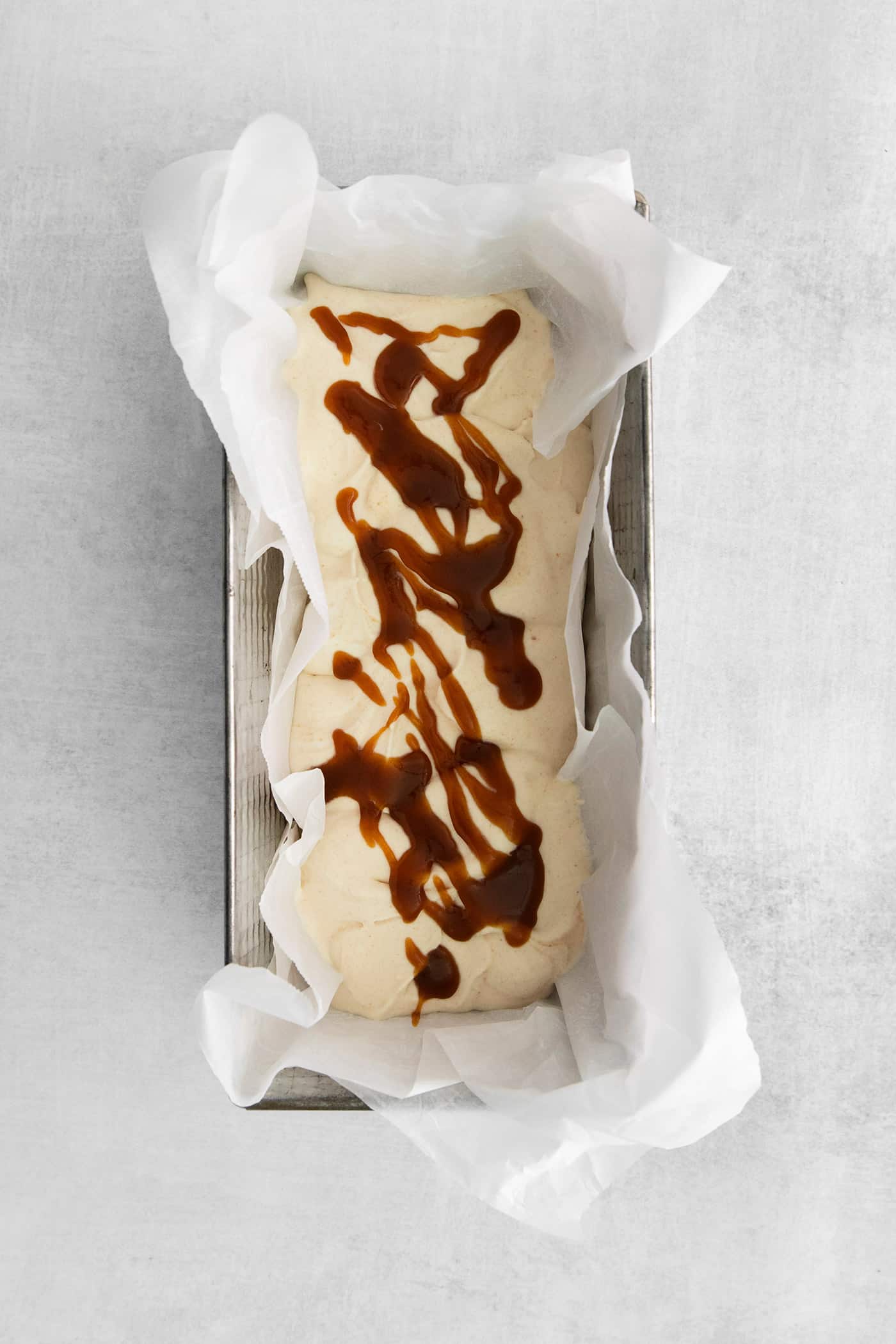 This Salted Caramel Ice Cream features a sweet and creamy ice cream base with homemade caramel sauce swirled throughout. A layer of ice cream topped with salted caramel drizzle