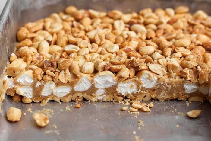 Salted Nut Roll Bars are the perfect salty and sweet combo, an easy riff on the classic candy bar. Just 5 ingredients and 15 minutes of prep! Side view of salted nut roll in pan after cutting, showing texture inside.