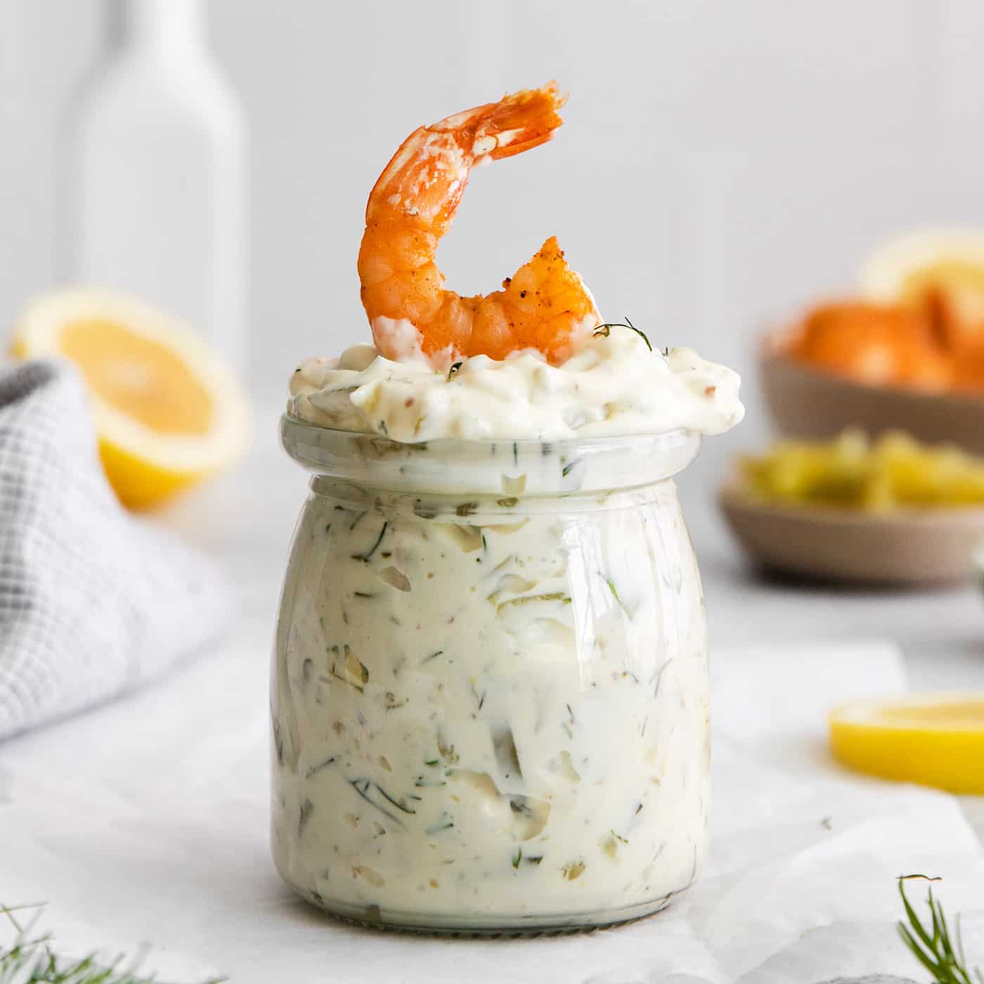 A jar of tartar sauce with a shrimp on top
