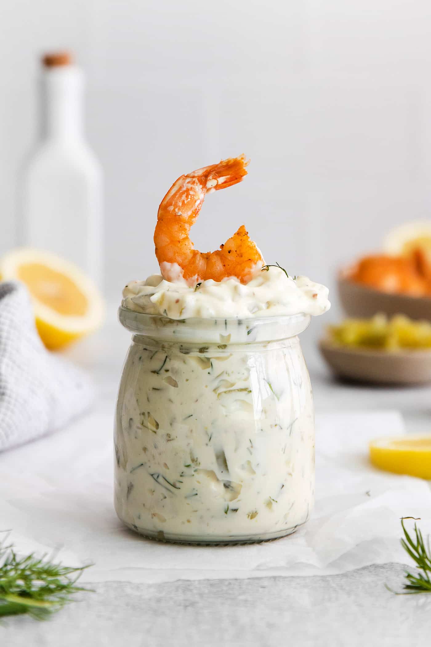 This Homemade Tartar Sauce is the perfect pairing for all your favorite seafood. Delightfully creamy with fresh dill and pickles. A jar of tartar sauce with a shrimp on top