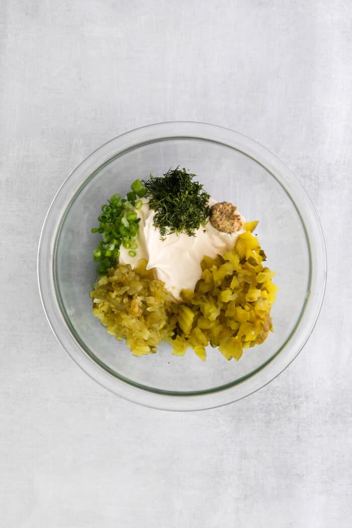 This Homemade Tartar Sauce is the perfect pairing for all your favorite seafood. Delightfully creamy with fresh dill and pickles. Tartar sauce ingredients in a bowl