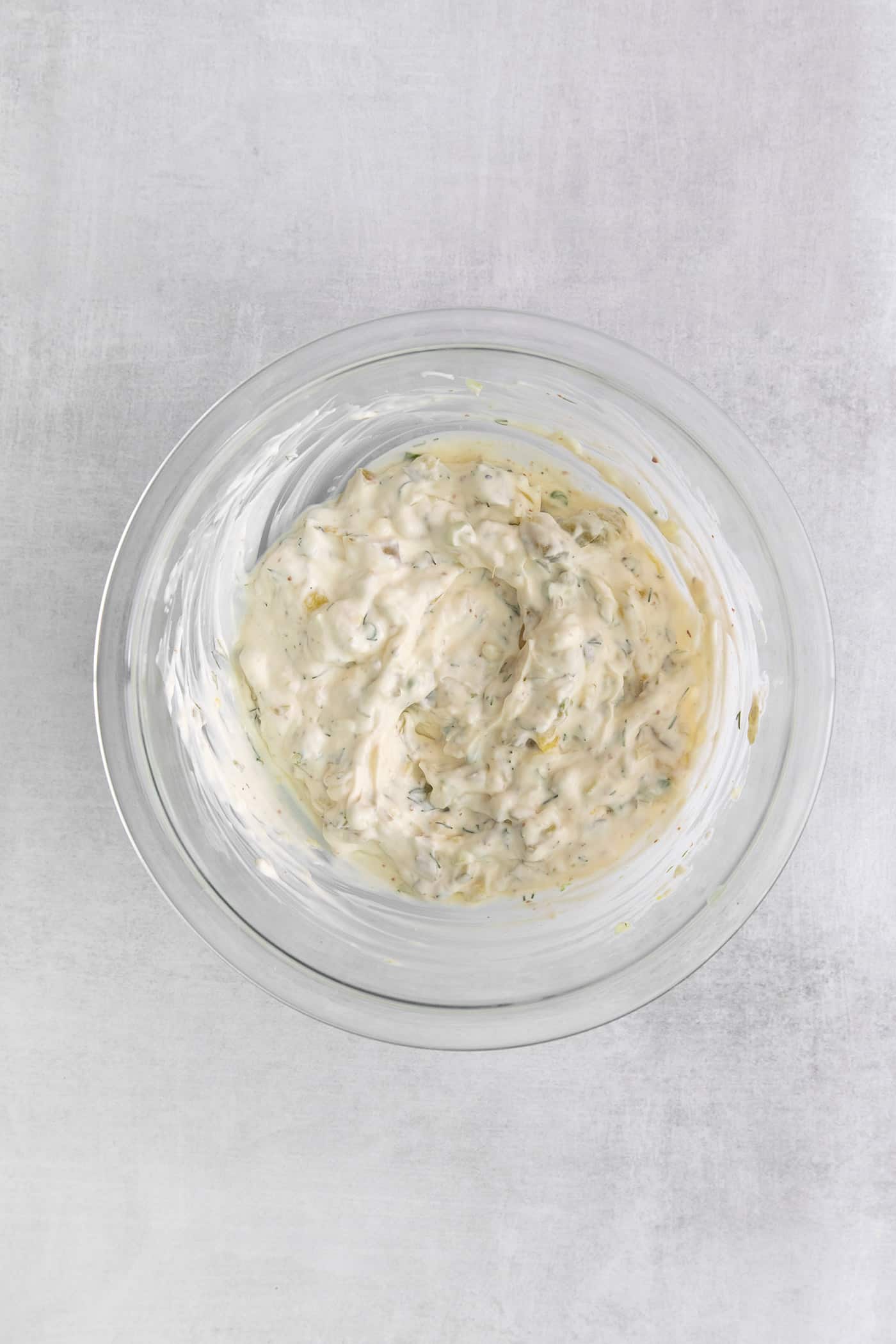 This Homemade Tartar Sauce is the perfect pairing for all your favorite seafood. Delightfully creamy with fresh dill and pickles. Overhead view of a mixing bowl of tartar sauce