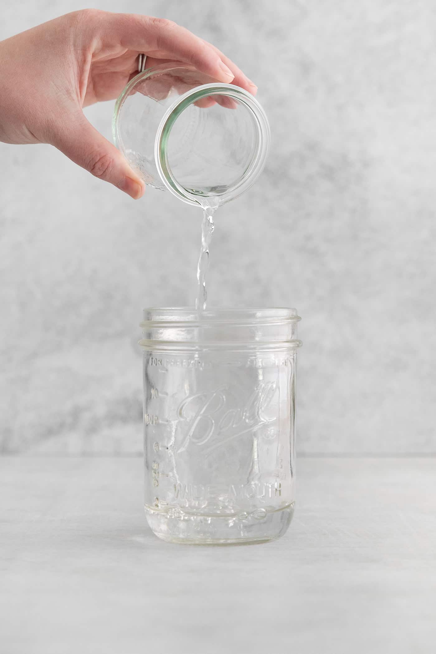 pouring tequila into a jar