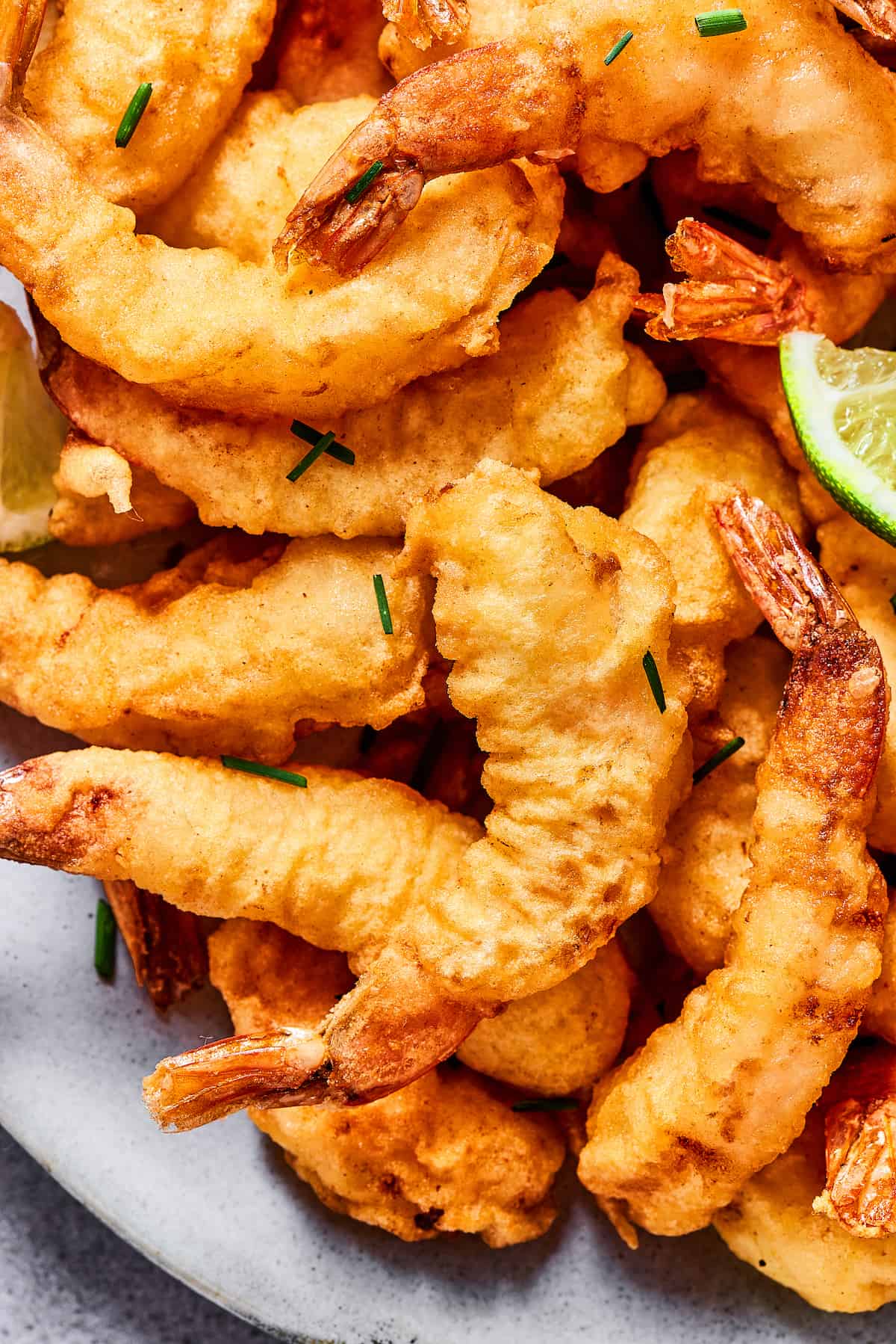 This easy shrimp tempura recipe features juicy, tender shrimp dipped in a light tempura batter. It's then deep-fried until perfectly crispy! Close-up of a plate of shrimp tempura