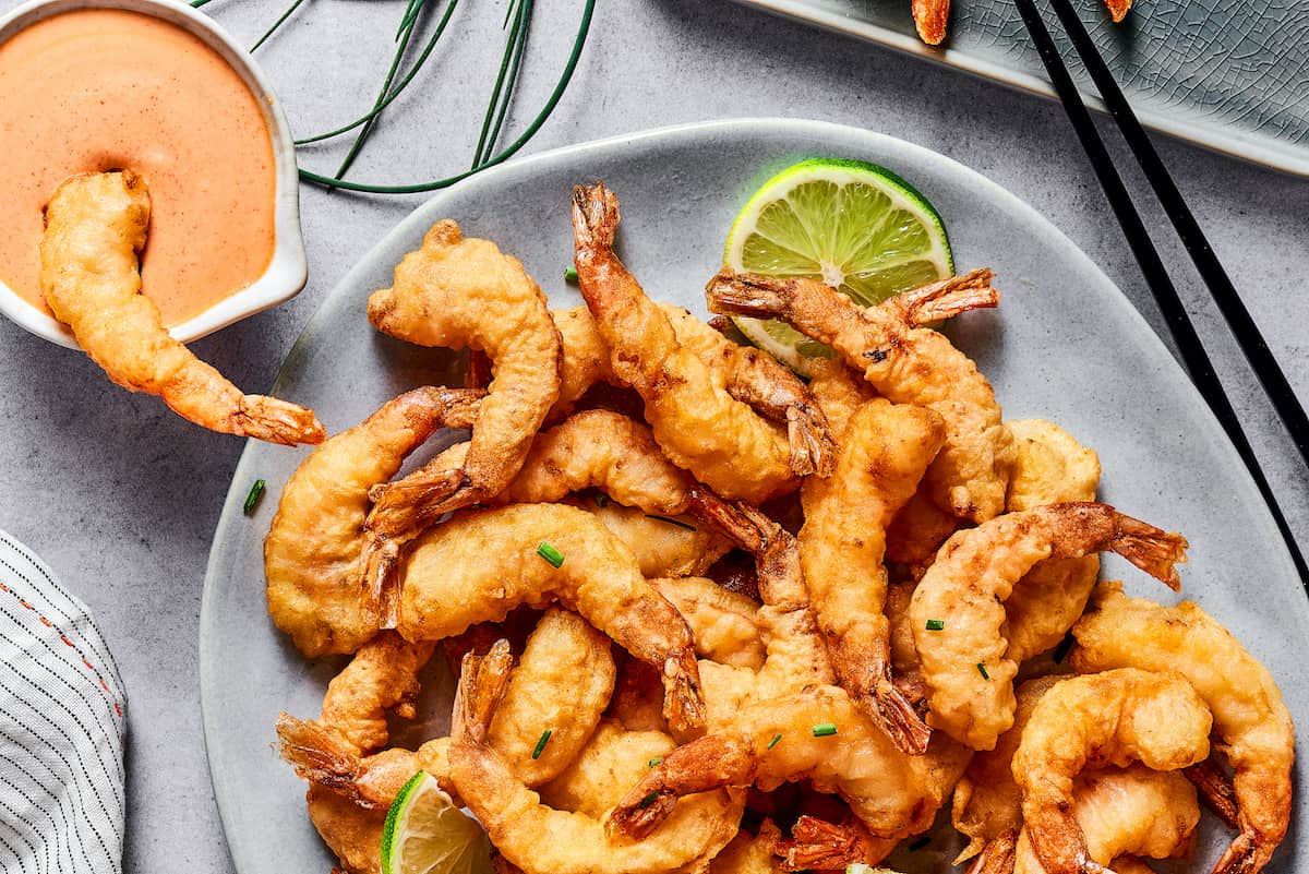 This easy shrimp tempura recipe features juicy, tender shrimp dipped in a light tempura batter. It's then deep-fried until perfectly crispy! Overhead view of a plate of shrimp tempura