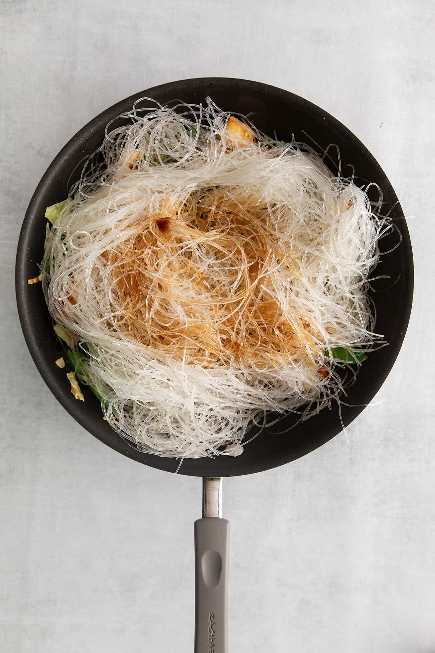 Made with glass noodles, mixed vegetables, and a savory soy glaze, Pad Woon Sen is an easy Thai stir fry that's ready in just 30 minutes! Glass noodles topped with sauce in a skillet