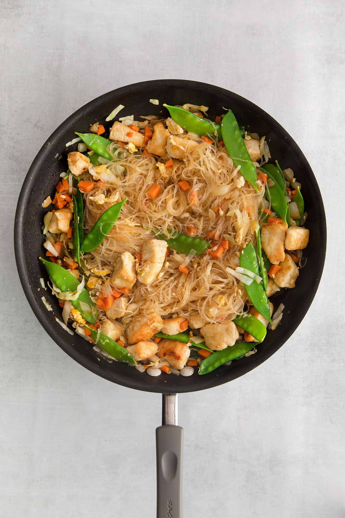 Made with glass noodles, mixed vegetables, and a savory soy glaze, Pad Woon Sen is an easy Thai stir fry that's ready in just 30 minutes! Glass noodle stir fry cooking in a skillet