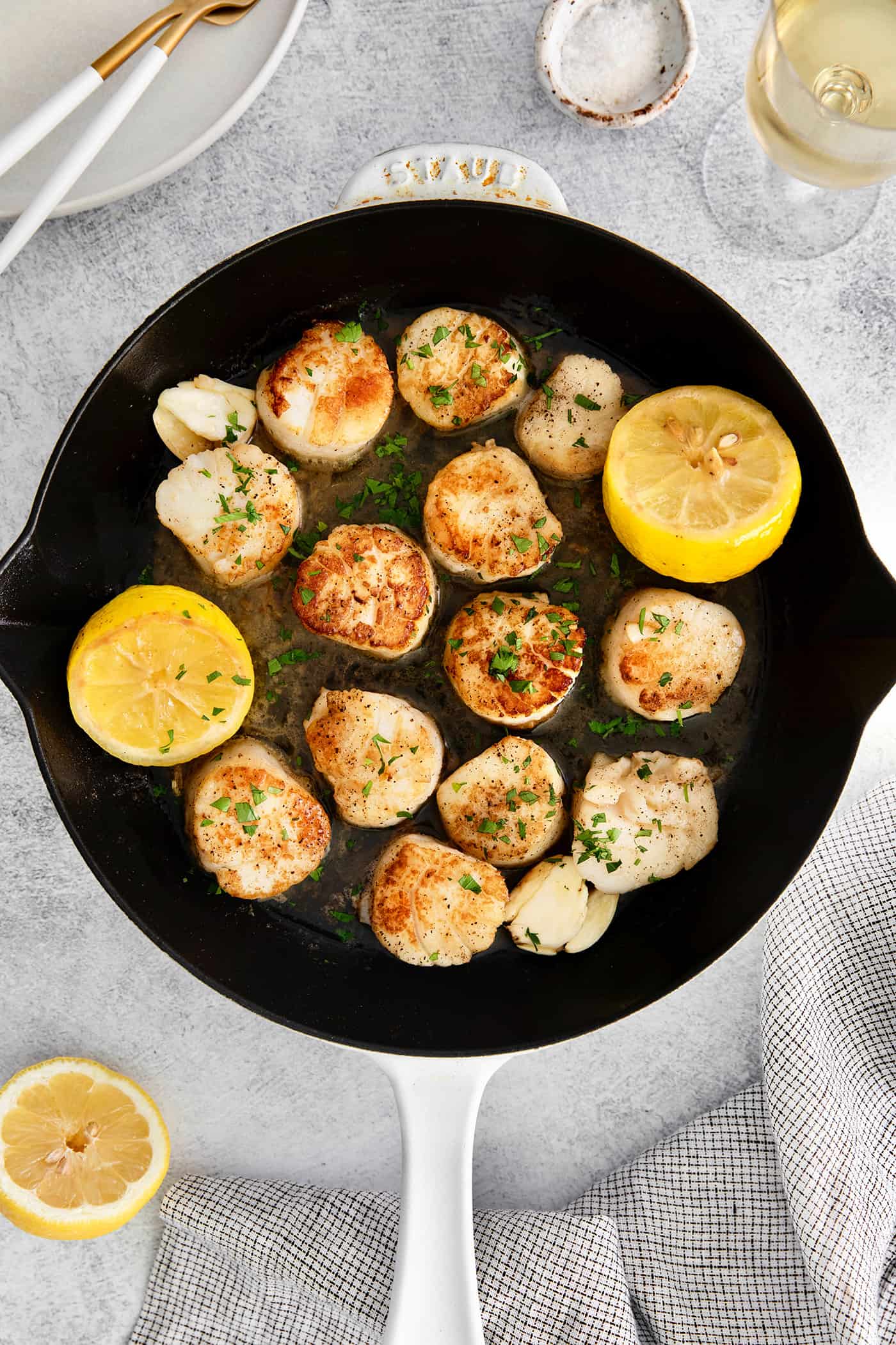Made with a simple lemon garlic butter sauce, these Pan Seared Scallops are guaranteed to be the highlight of any dinner. Seared scallops in a cast iron skillet with lemon