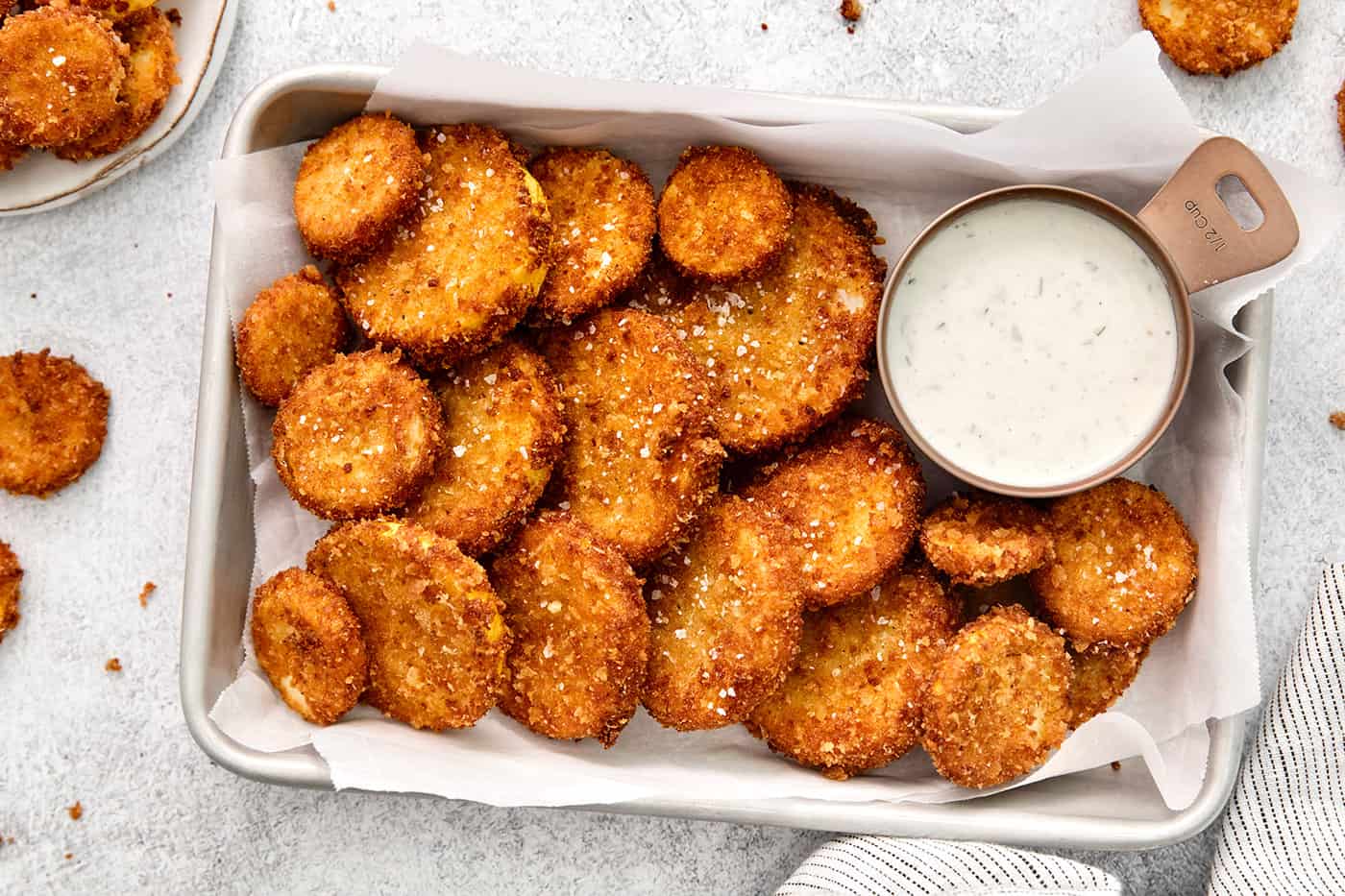 This easy, flavorful fried yellow squash is delightfully crispy on the outside and tender on the inside. Grab your favorite dip and enjoy! Overhead view of fried squash with a dish of ranch dressing
