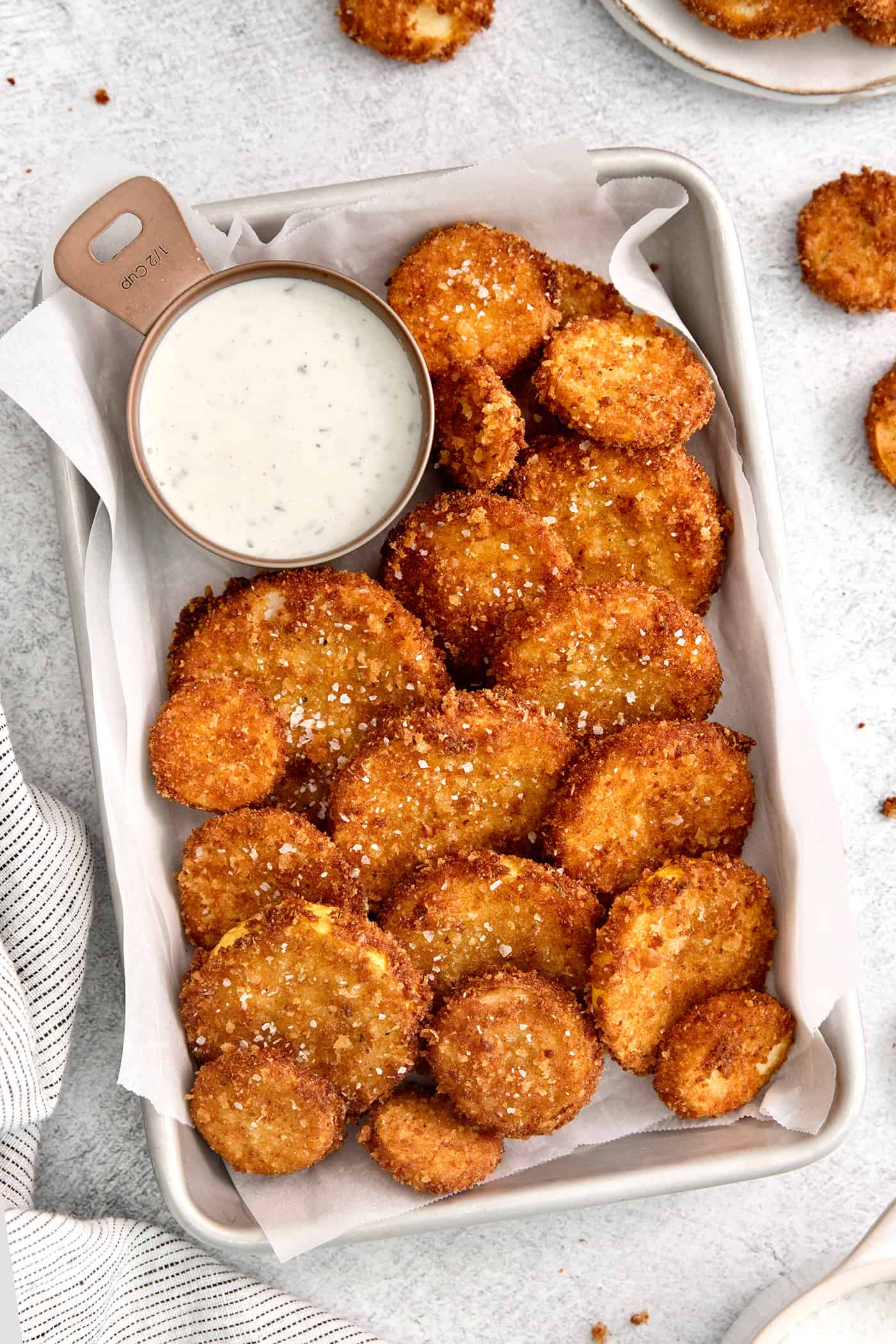 This easy, flavorful fried yellow squash is delightfully crispy on the outside and tender on the inside. Grab your favorite dip and enjoy! Overhead view of fried squash with a dish of ranch