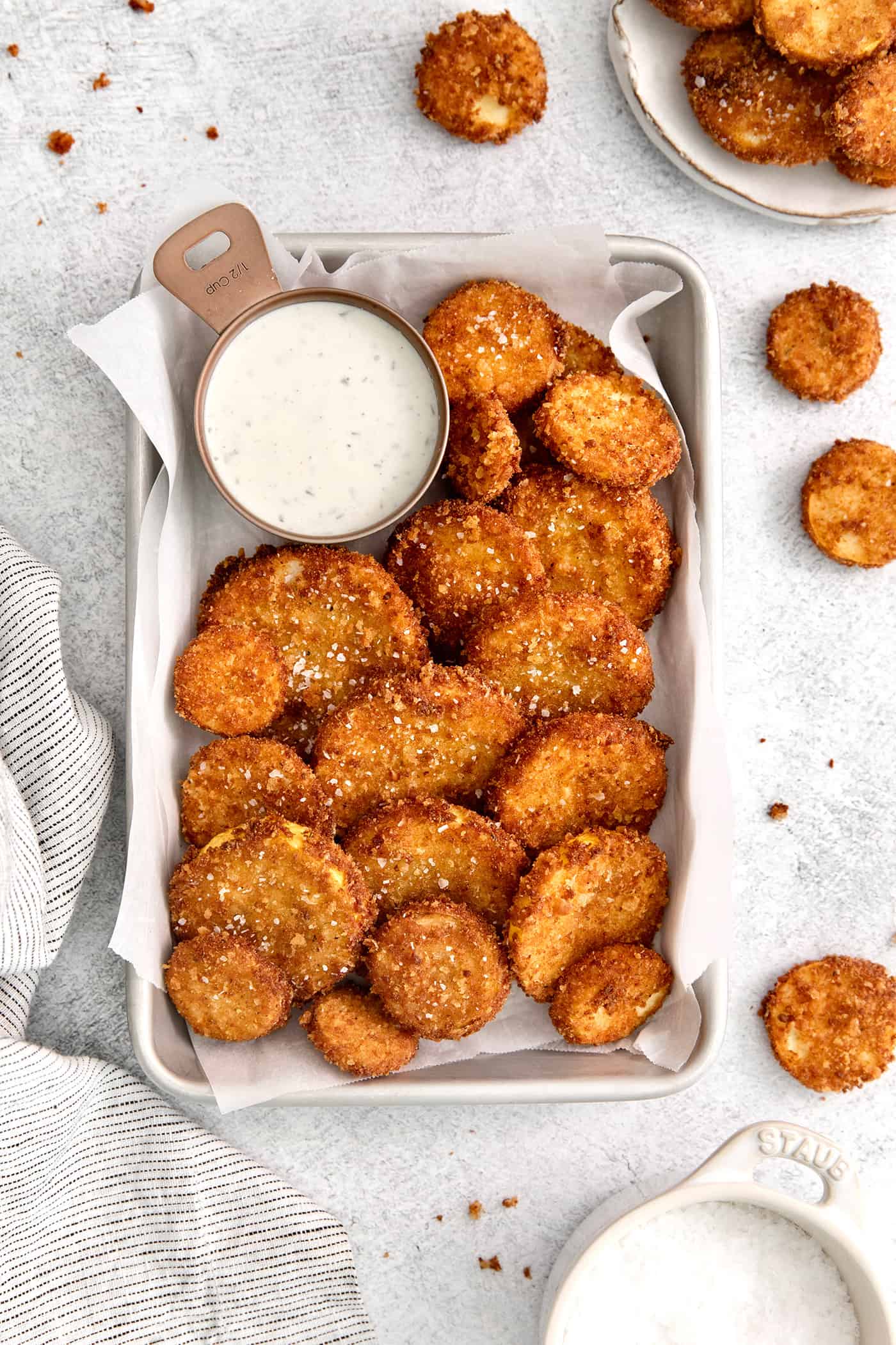 This easy, flavorful fried yellow squash is delightfully crispy on the outside and tender on the inside. Grab your favorite dip and enjoy! Fried squash on a platter with a dish of ranch