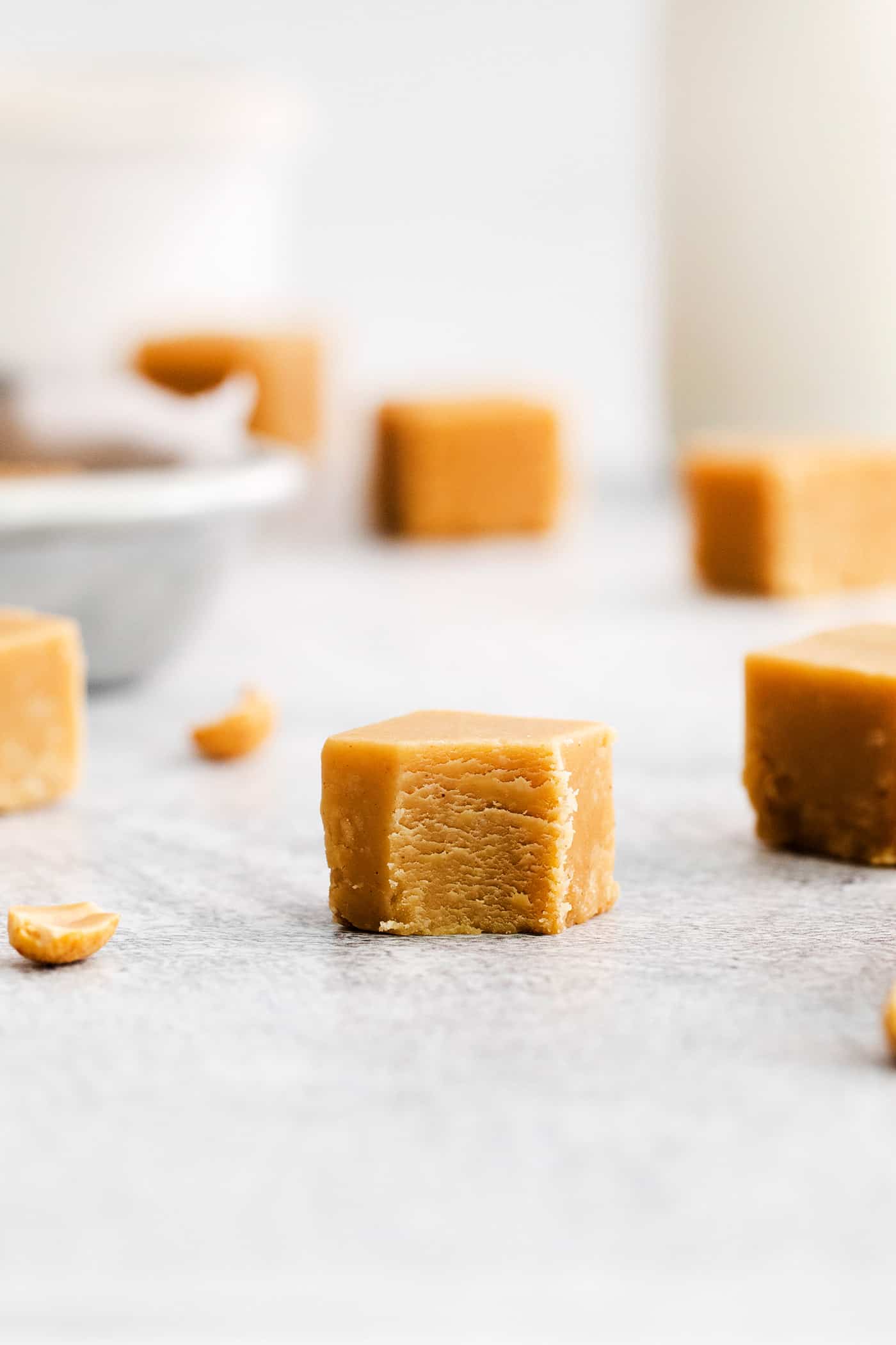 Made with 7 ingredients, this Homemade Peanut Butter Fudge is rich, creamy, and easy to make. It's the perfect fudge for the holidays! A side view of a piece of fudge with a bite missing
