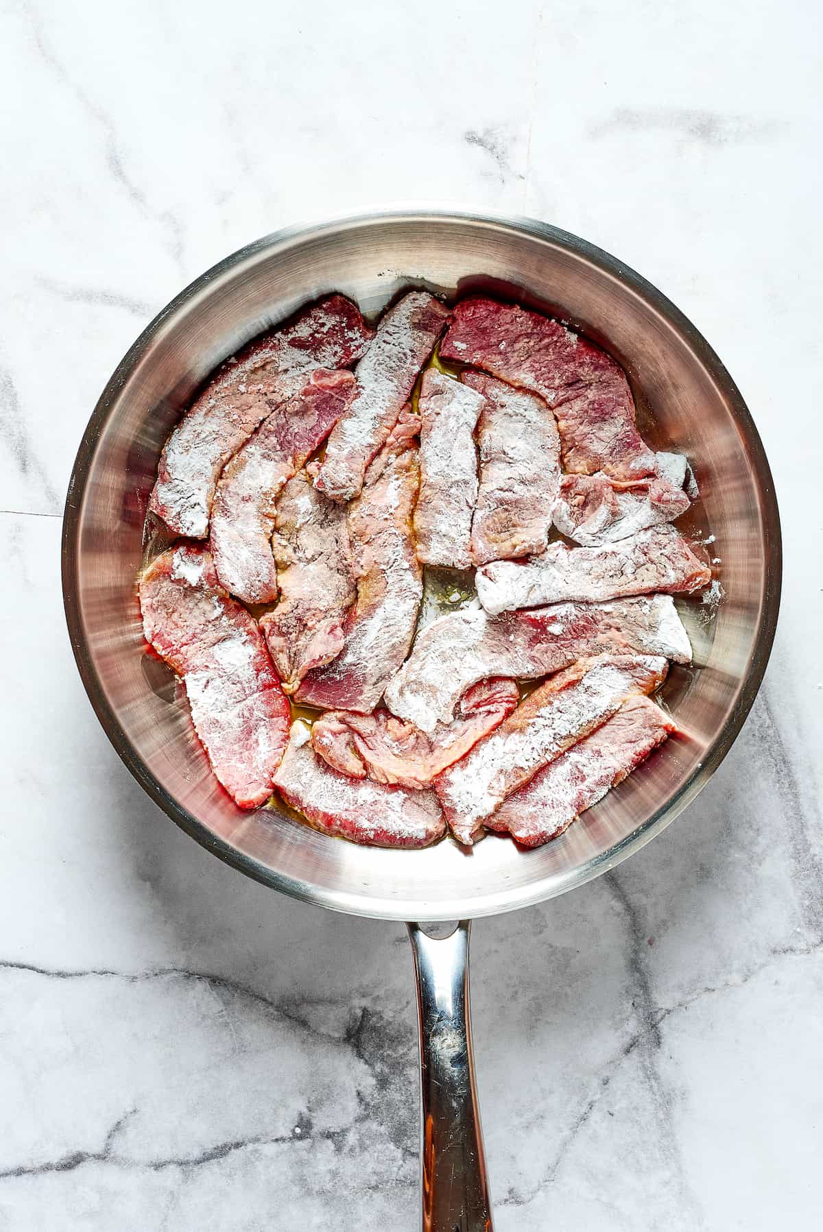 This Easy Hunan Beef recipe is better than take-out! Made with strips of steak, peppers, and onions in a savory, mildly hot, and tangy sauce. Slices of beef coated in cornstarch