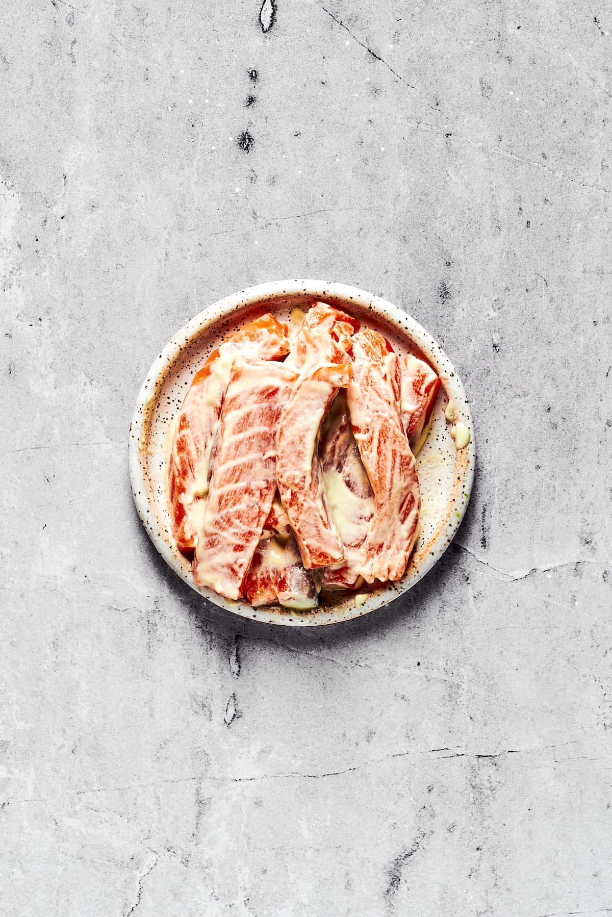 This Sushi Burrito recipe results in a giant sushi roll stuffed with spicy salmon, rice, avocado, carrots, and other veggies. Sliced salmon in spicy mayo