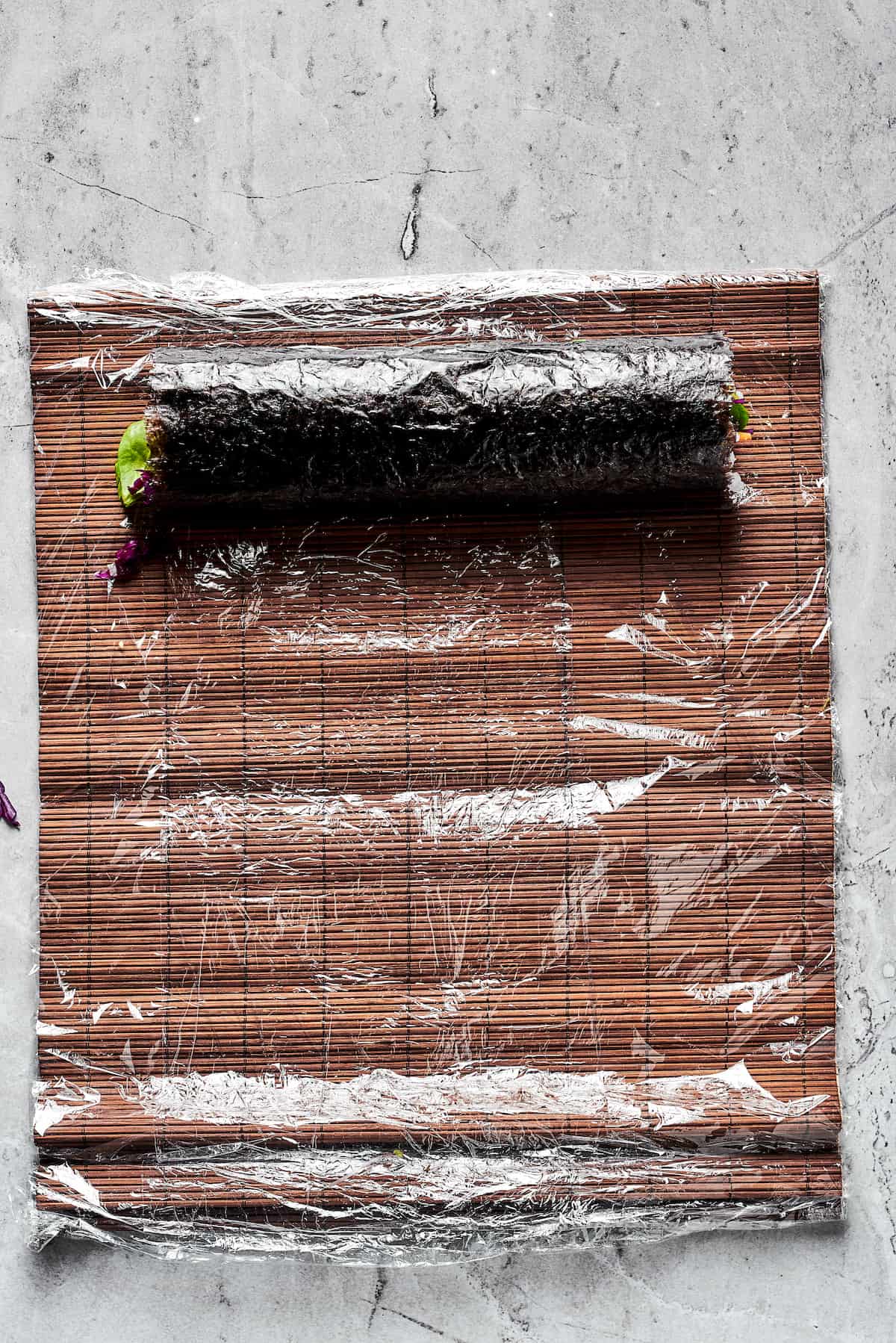 This Sushi Burrito recipe results in a giant sushi roll stuffed with spicy salmon, rice, avocado, carrots, and other veggies. A sushi burrito