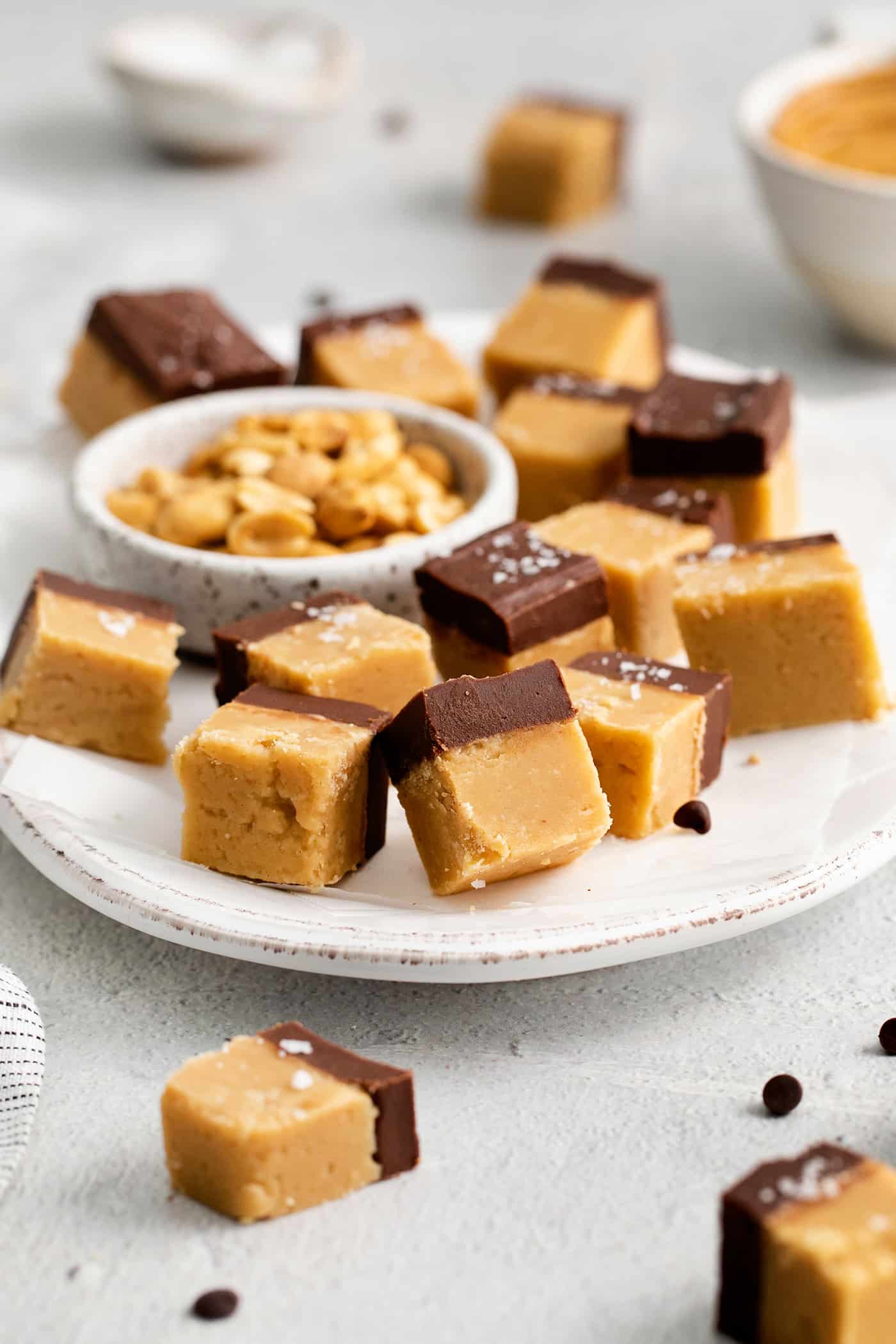 This Buckeye Fudge is a fun twist on traditional buckeyes, with smooth, creamy peanut butter fudge topped with a layer of rich chocolate. Chocolate peanut butter fudge on a white plate