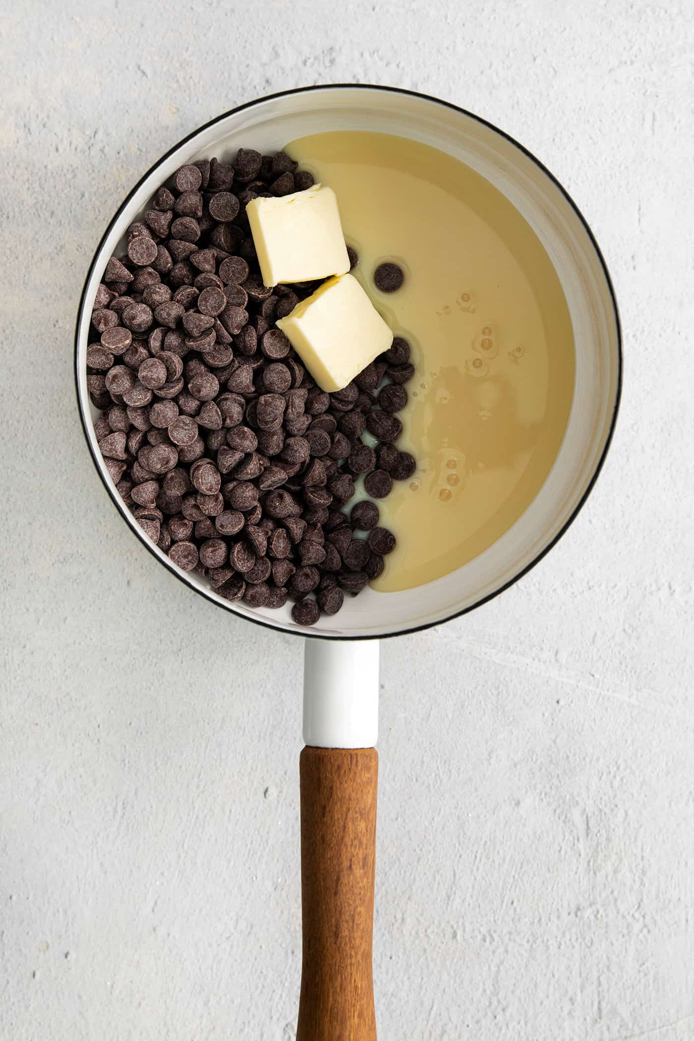 This Buckeye Fudge is a fun twist on traditional buckeyes, with smooth, creamy peanut butter fudge topped with a layer of rich chocolate. Chocolate chips, condensed milk, and butter in a saucepan