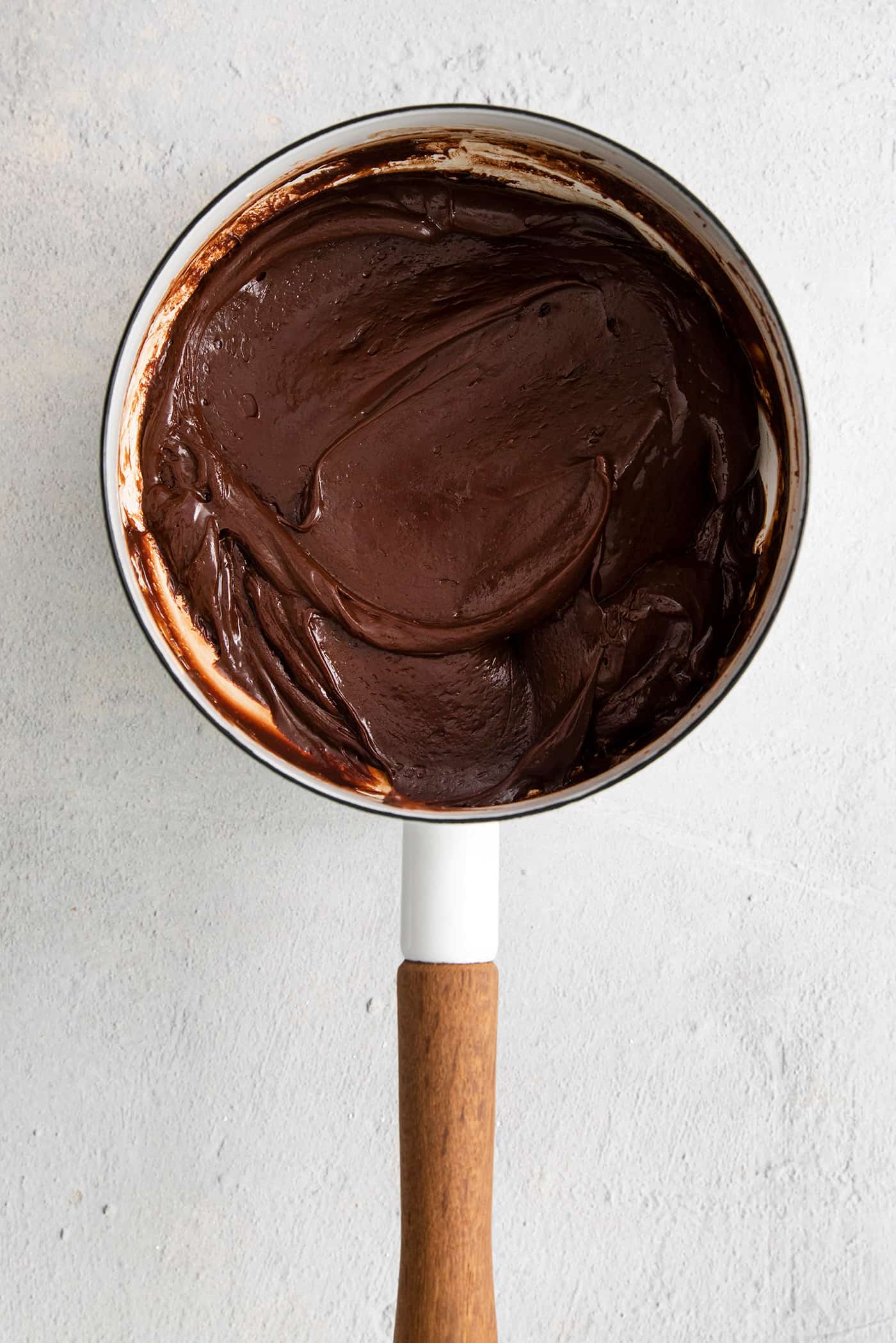 This Buckeye Fudge is a fun twist on traditional buckeyes, with smooth, creamy peanut butter fudge topped with a layer of rich chocolate. Melted chocolate in a saucepan