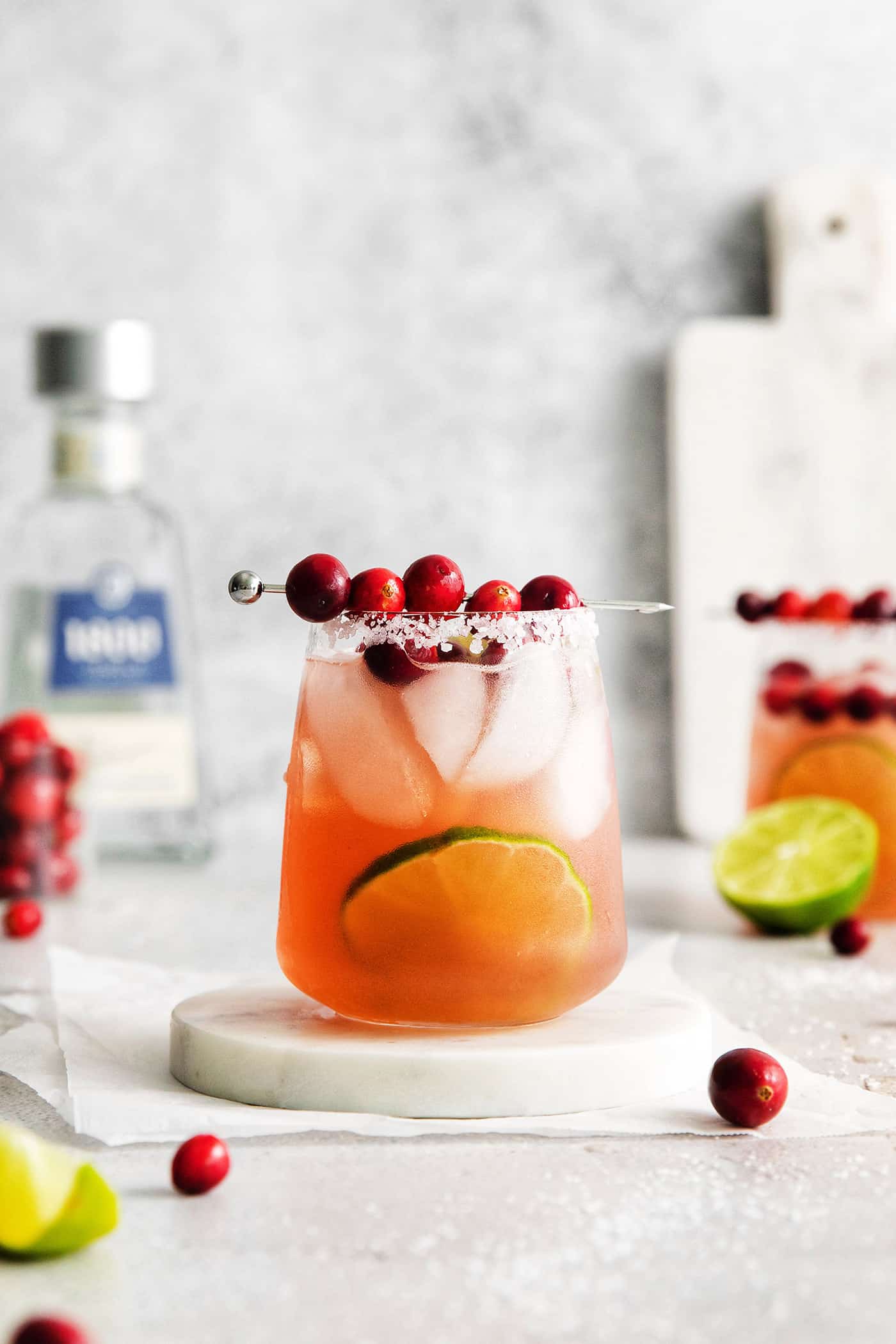 This Cranberry Margarita is tart and refreshing with flavors of cranberry and lime. A great Christmas margarita option! Cranberry margarita on a white coaster