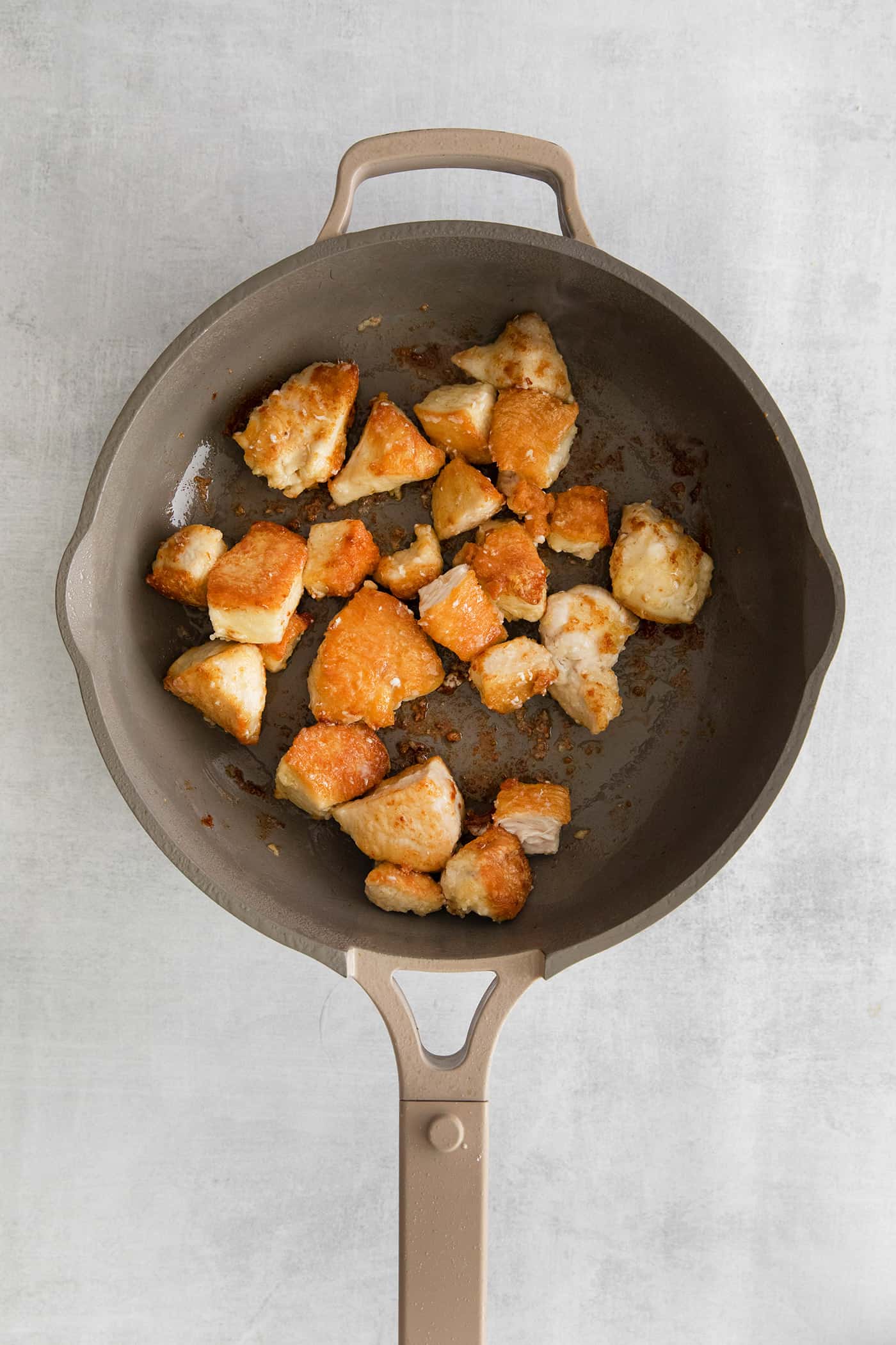 These Honey Garlic Chicken Bowls are quick and easy with moist chunks of chicken tossed in a sweet and sticky garlic sauce. Chunks of chicken sauteing in a skillet