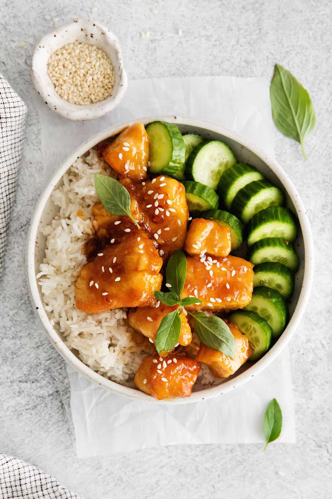 These Honey Garlic Chicken Bowls are quick and easy with moist chunks of chicken tossed in a sweet and sticky garlic sauce. Overhead view of a chicken rice bowl