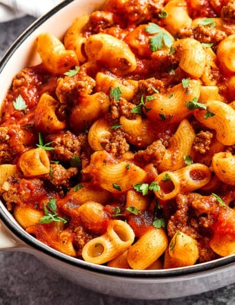 a white Dutch oven full of beefaroni