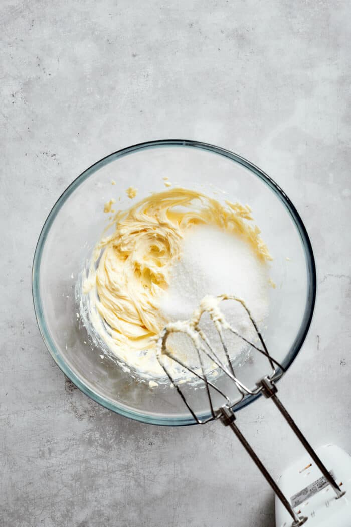 Mixing fluffy whipped butter with sugar.