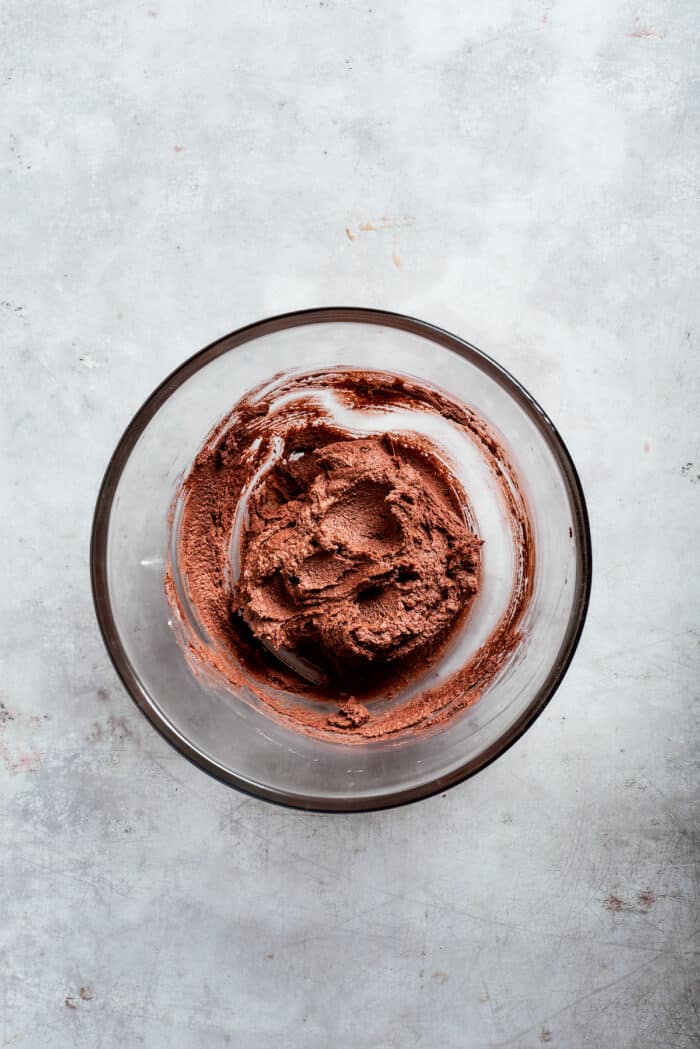Chocolate cookie dough batter in a glass bowl.
