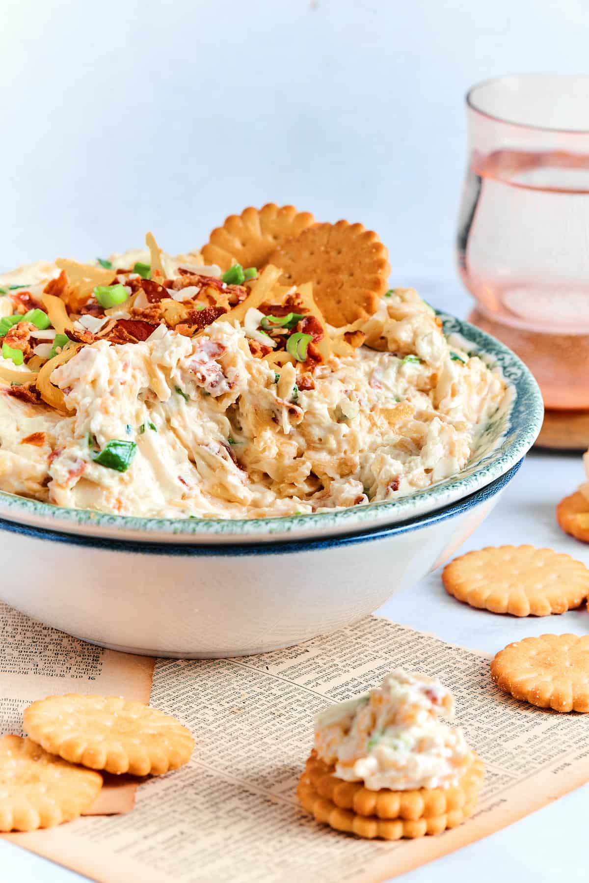 Million Dollar Dip is creamy, cheesy, and super easy to make. With cheese, bacon, and almonds, it's a super addicting party dip. Neiman marcus cheese dip in a white and blue bowl with Ritz crackers