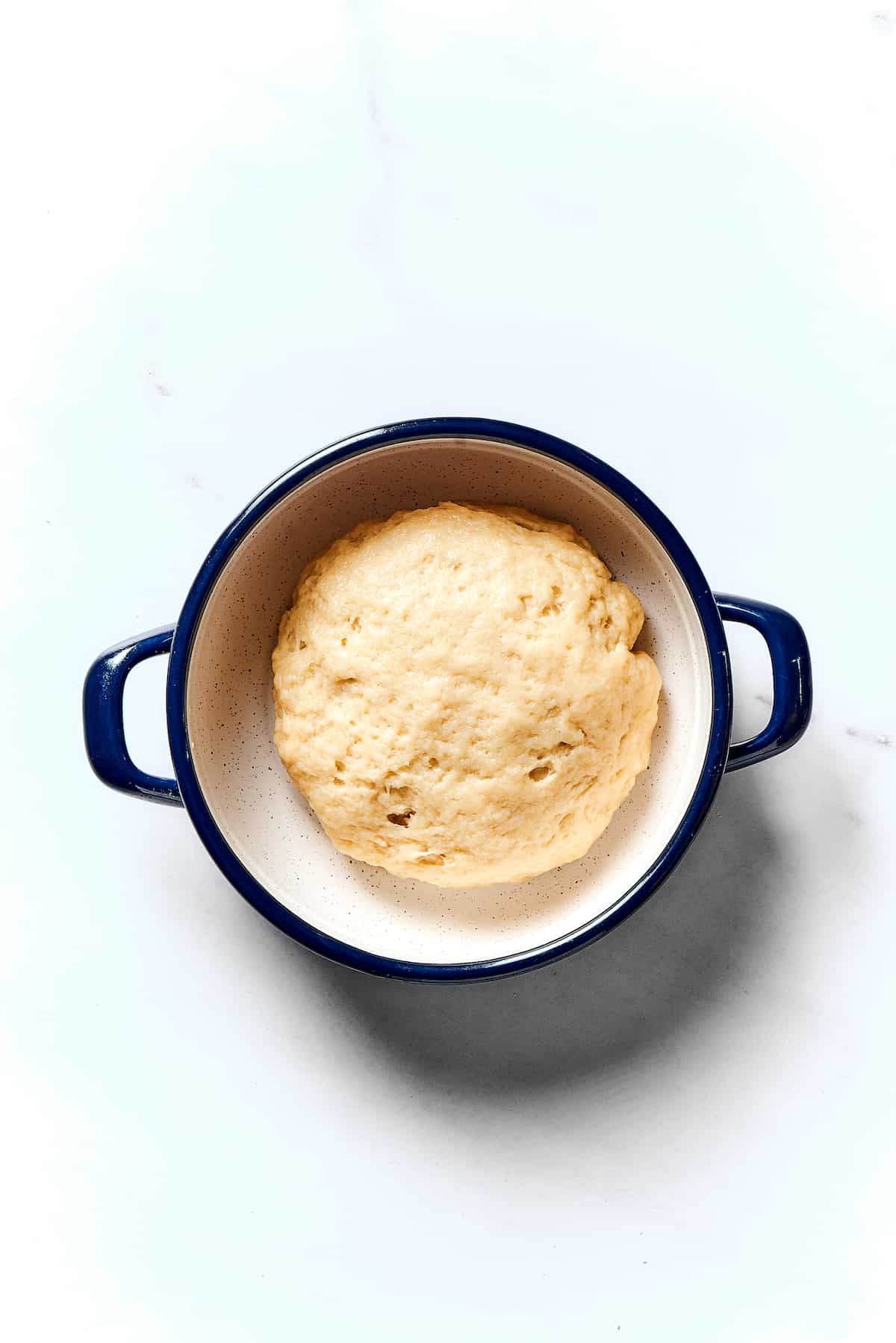 Potato Knishes are a popular Jewish recipe featuring a mashed potato and onion filling wrapped in a thin, flaky dough and baked to golden. A ball of dough in a pot