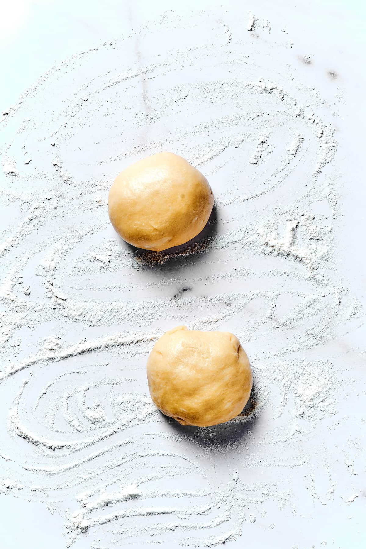 Potato Knishes are a popular Jewish recipe featuring a mashed potato and onion filling wrapped in a thin, flaky dough and baked to golden. Two small balls of dough