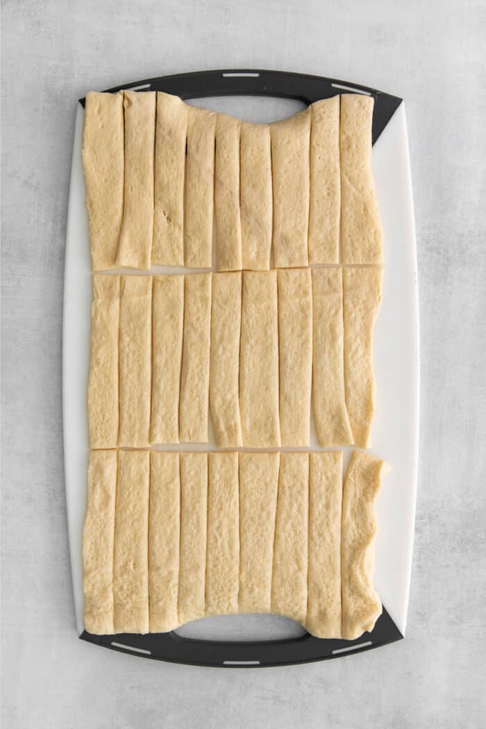 Everything Bagel Pigs in a Blanket are the perfect appetizer– mini sausage wrapped in crescent dough, topped with everything bagel seasoning A sheet of crescent dough cut into strips