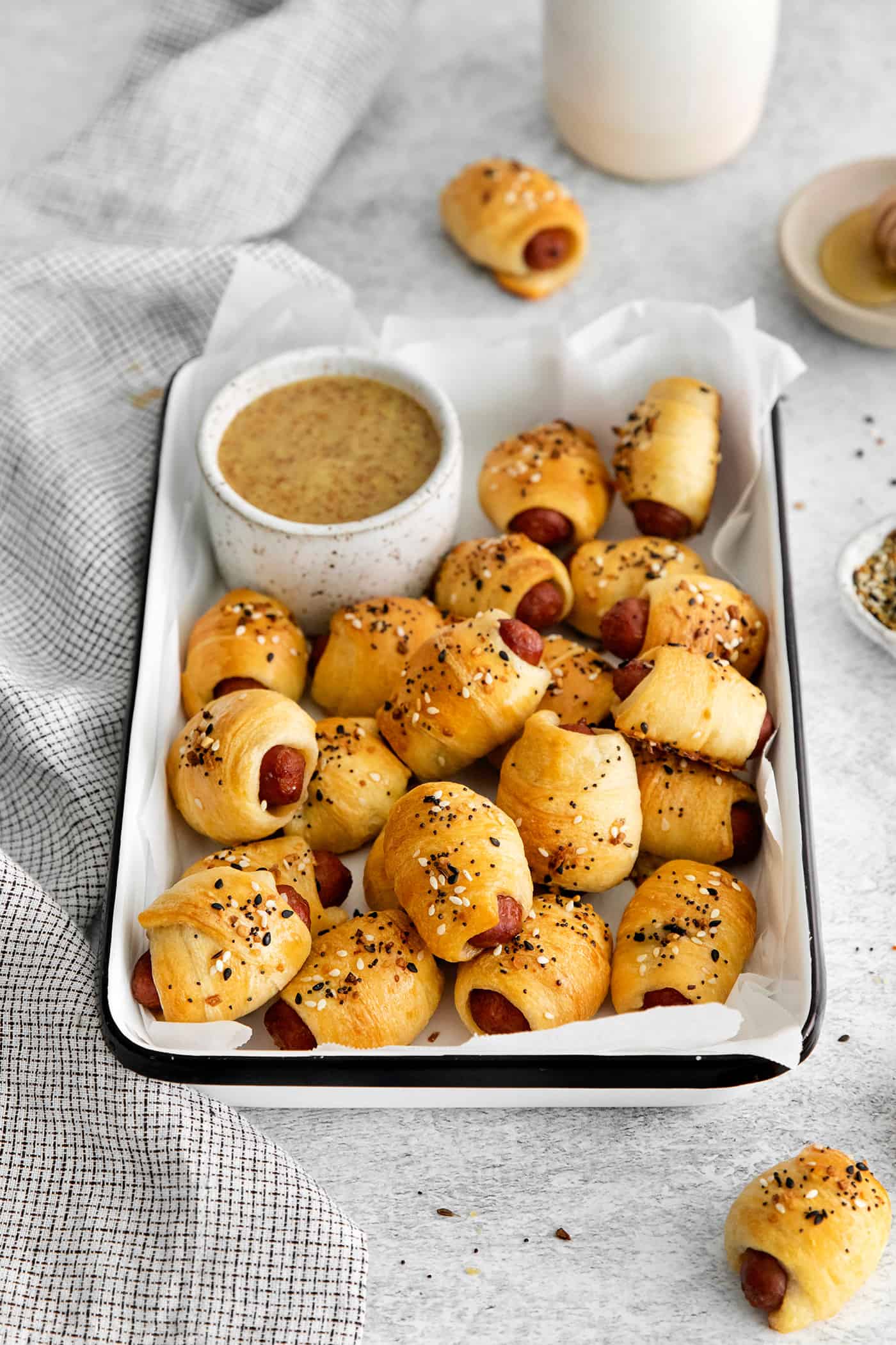 Everything Bagel Pigs in a Blanket are the perfect appetizer– mini sausage wrapped in crescent dough, topped with everything bagel seasoning Mini pigs in a blanket in a tray