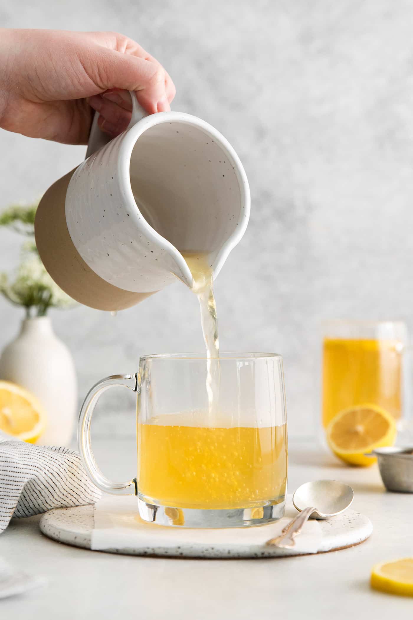Made with citrus mint and peach tea, lemon, and honey, Starbucks Medicine Ball Recipe is just the thing for those chilly months. Tea being poured into a glass mug