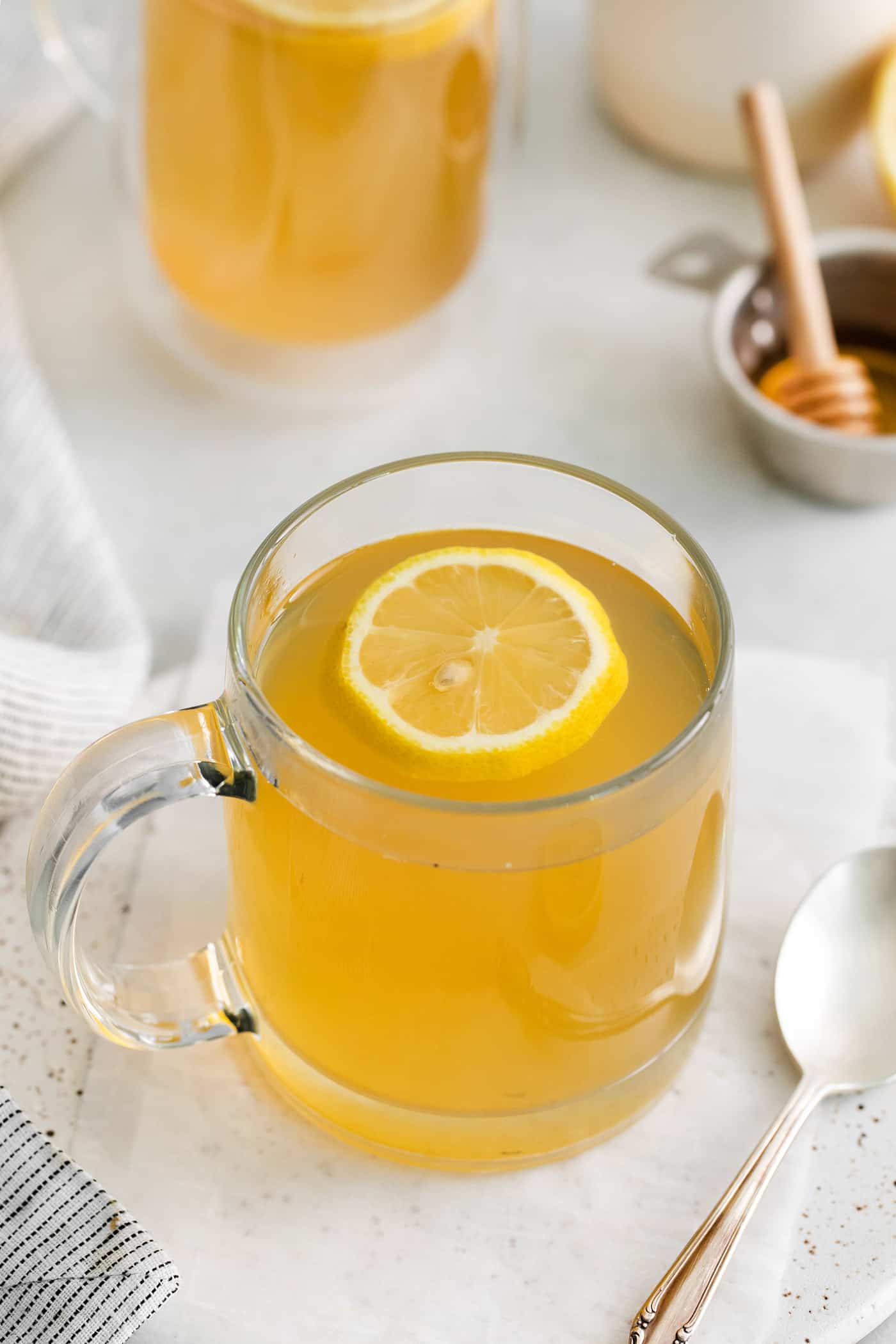 Made with citrus mint and peach tea, lemon, and honey, Starbucks Medicine Ball Recipe is just the thing for those chilly months. Angled view of a mug of honey citrus mint tea with a slice of lemon