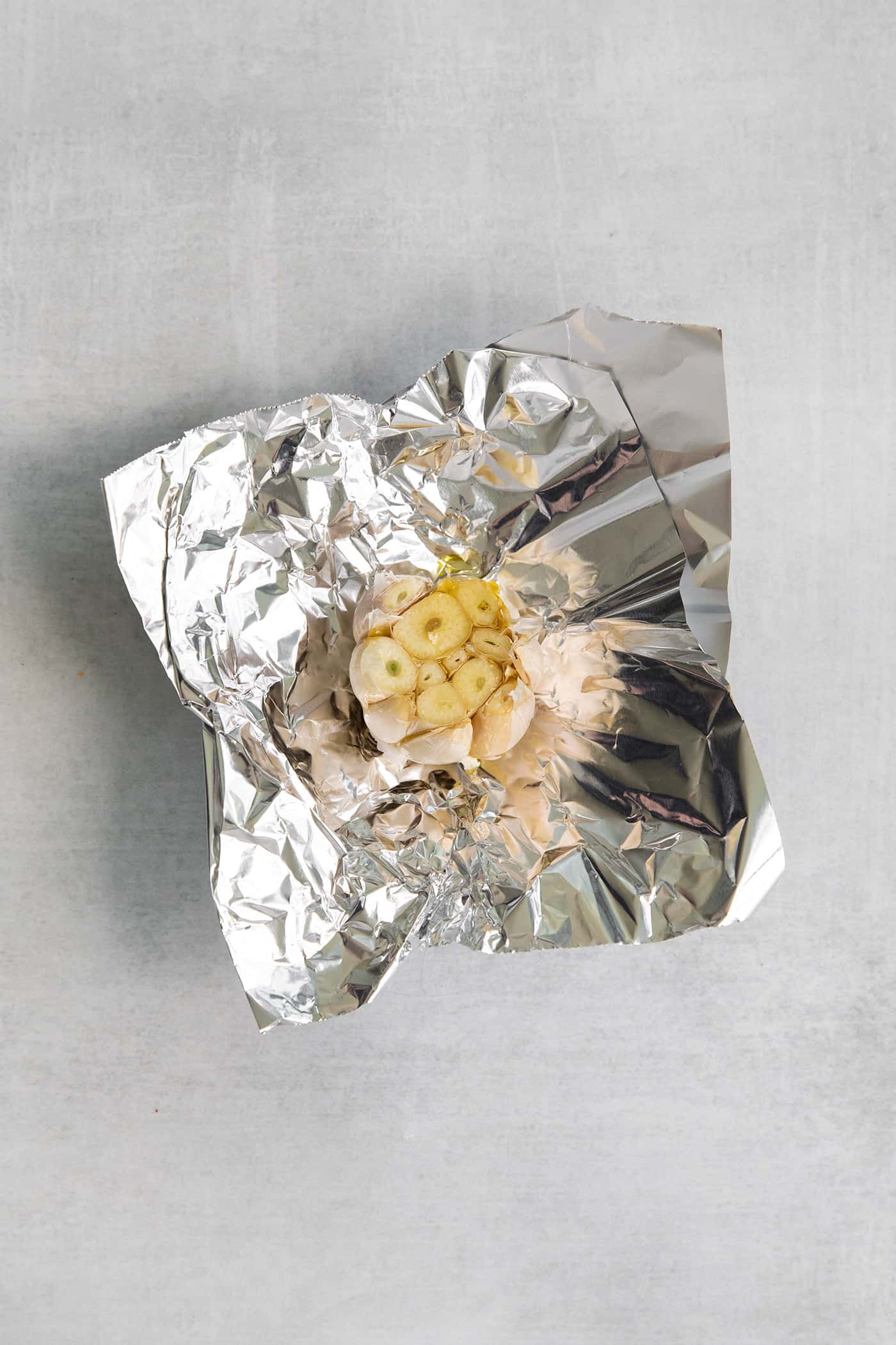 Parsnip Puree is a tasty side dish that is simple enough for every day but impressive enough for the holidays! A head of garlic on a piece foil