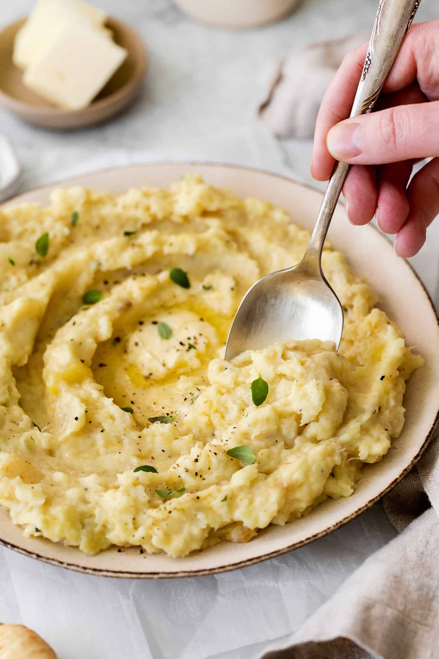 Parsnip Puree is a tasty side dish that is simple enough for every day but impressive enough for the holidays! A spoon digging into a plate of parsnip puree
