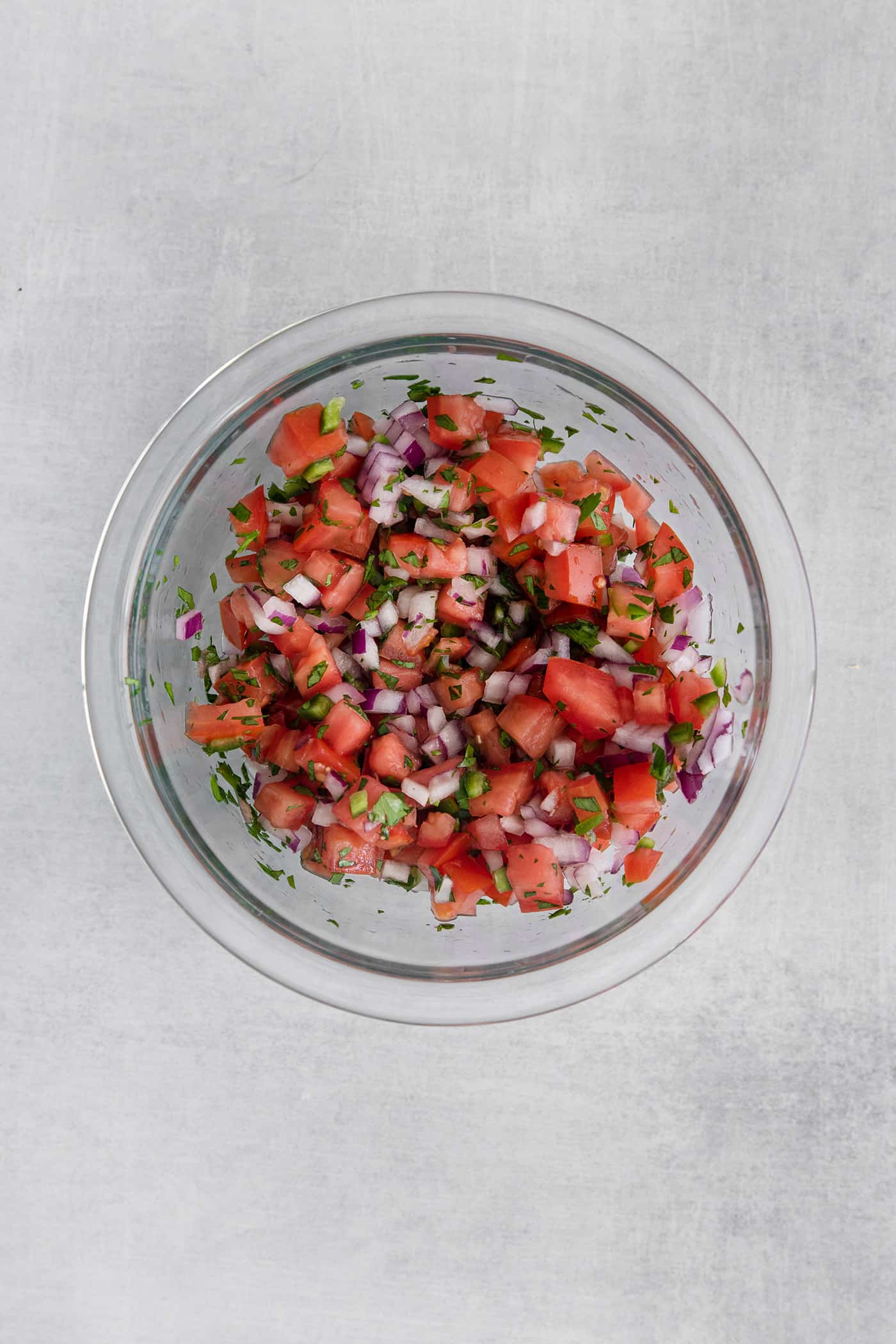 These Tex-Mex Scallop Rice Bowls are bright, refreshing, and packed with flavor, with scallops, pico de gallo, and lime crema. Homemade pico de gallo in a glass bowl